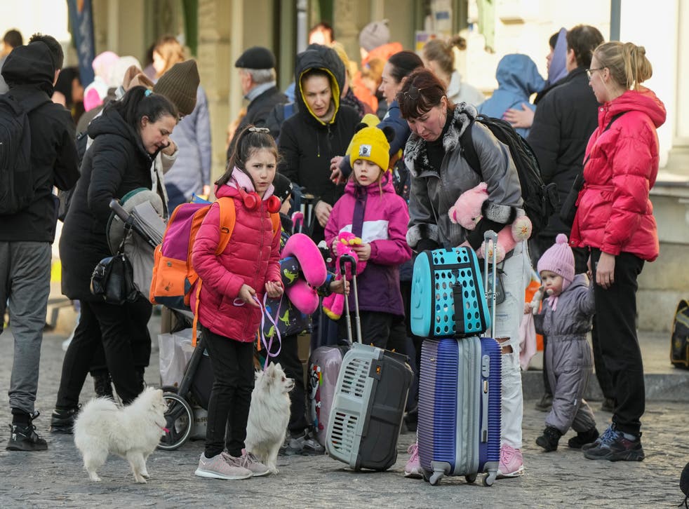 Refugees with children wait for a transport after fleeing the war from neighbouring Ukraine at a railway station in Przemysl, Poland (Sergei Grits/AP)