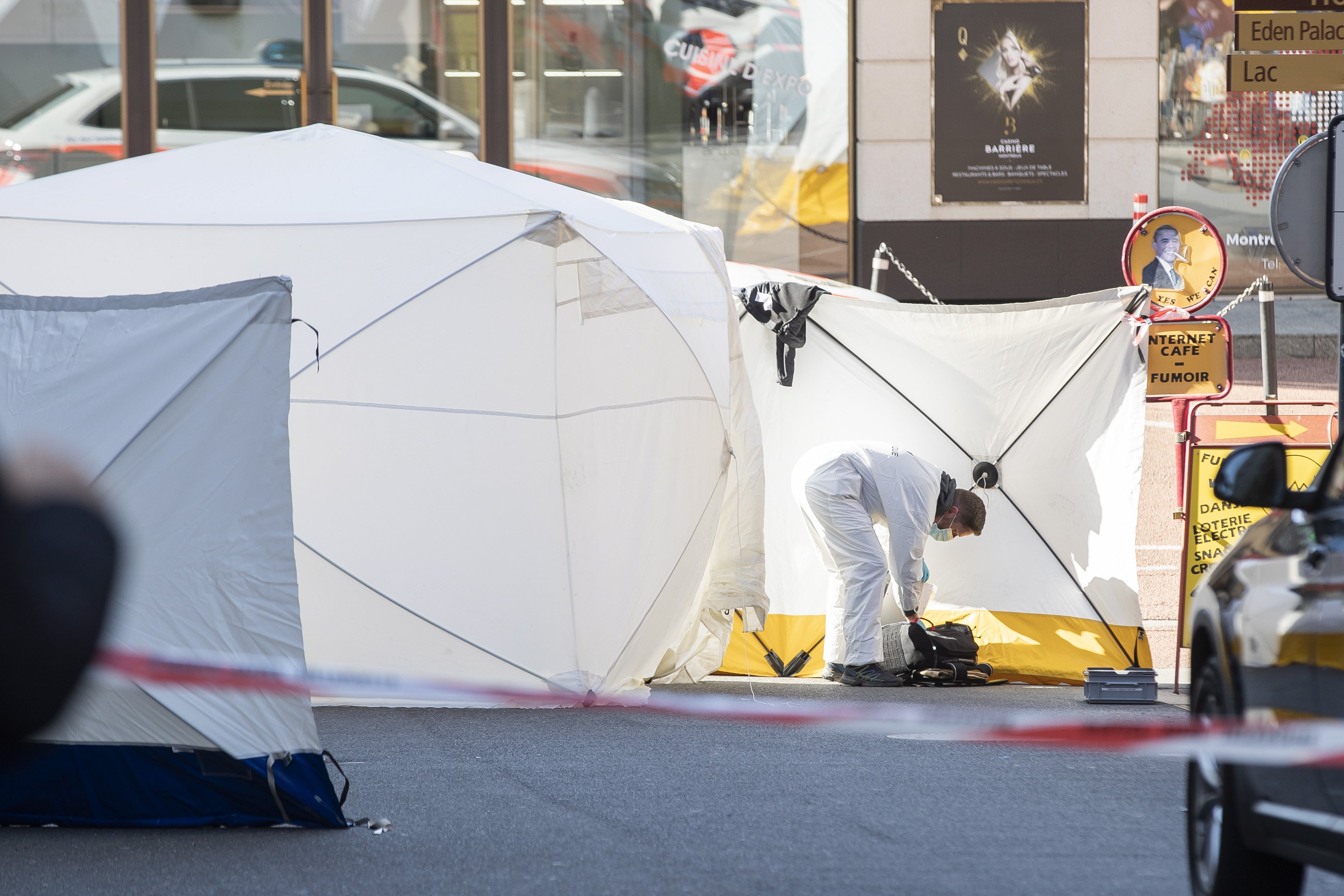 A forensic officer from the Vaud cantonal police investigates at the scene of the tragedy where four people died and one was seriously injured after falling from their flat in Montreux