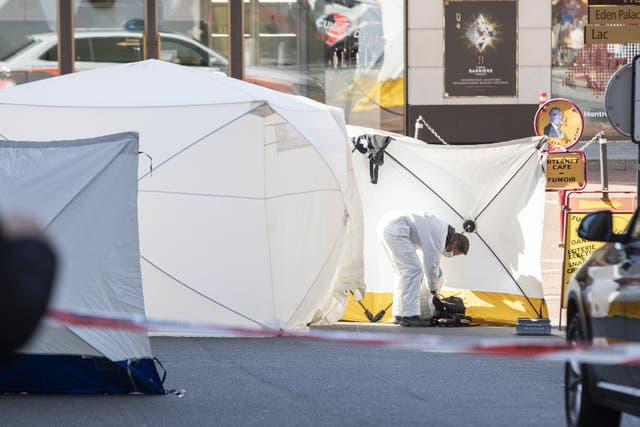 <p>A forensic officer from the Vaud cantonal police investigates at the scene of the tragedy where four people died and one was seriously injured after falling from their flat in Montreux</p>