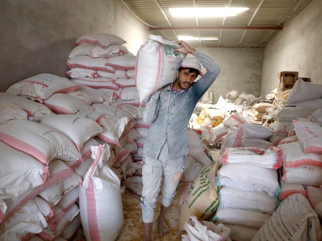 <p>A Yemeni worker handles imported wheat grain as global prices spike </p>