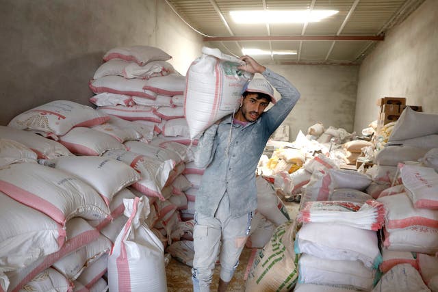 <p>A Yemeni worker handles imported wheat grain as global prices spike </p>
