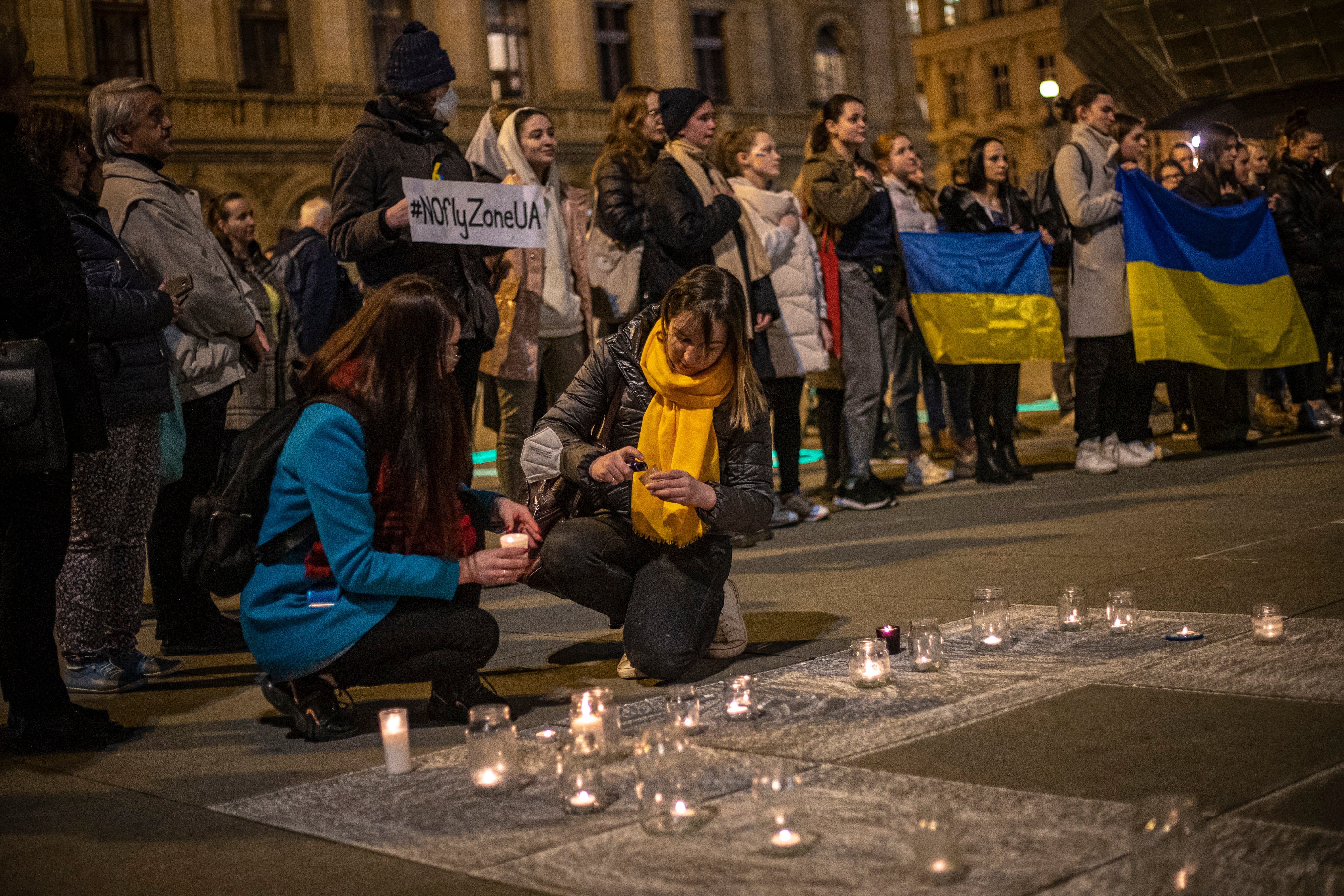 People at a peace rally in Prague light candles for those killed in the Mariupol theatre