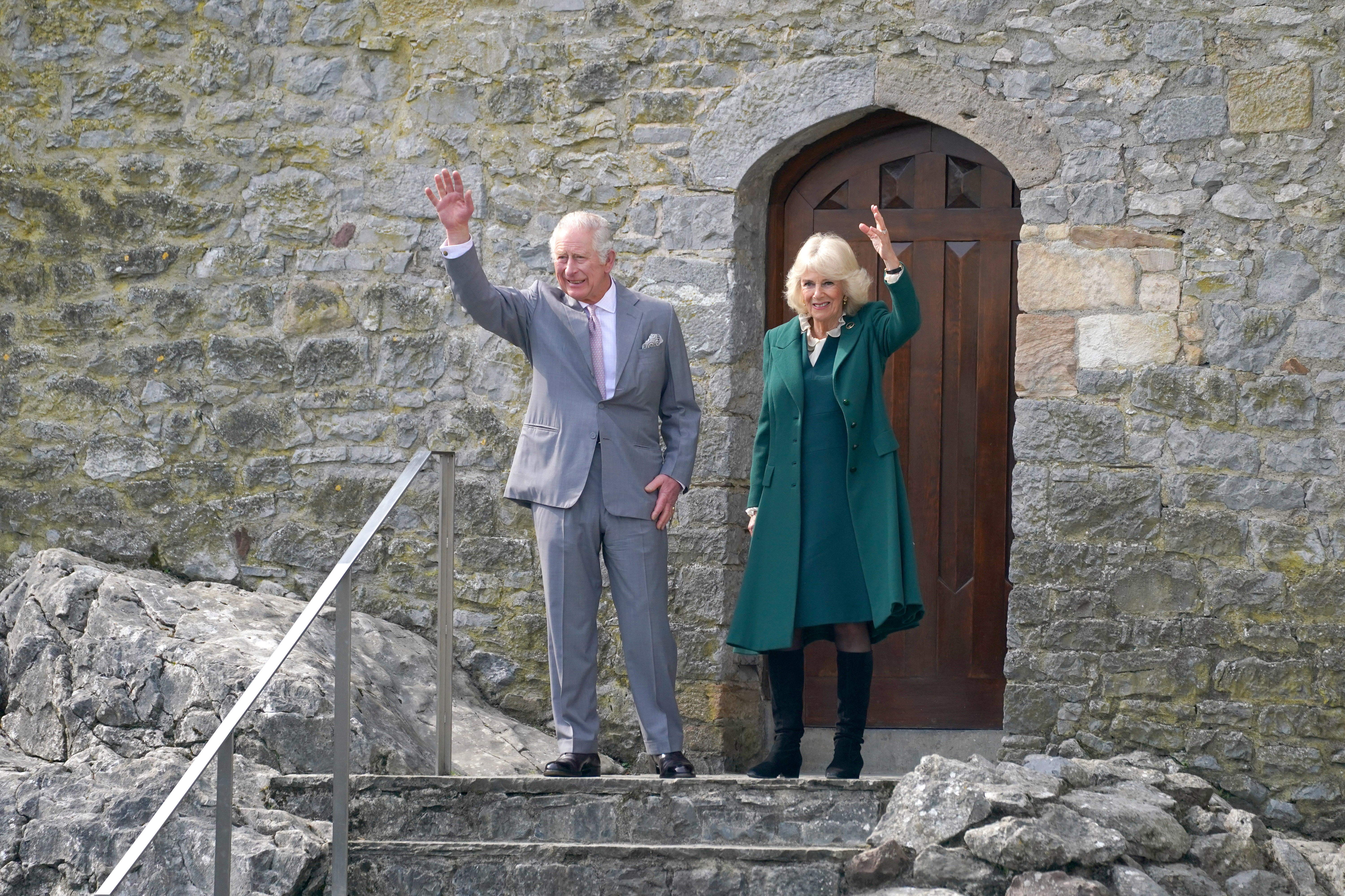 The Prince of Wales and the Duchess of Cornwall wave as they leave Cahir Castle (Brian Lawless/PA)