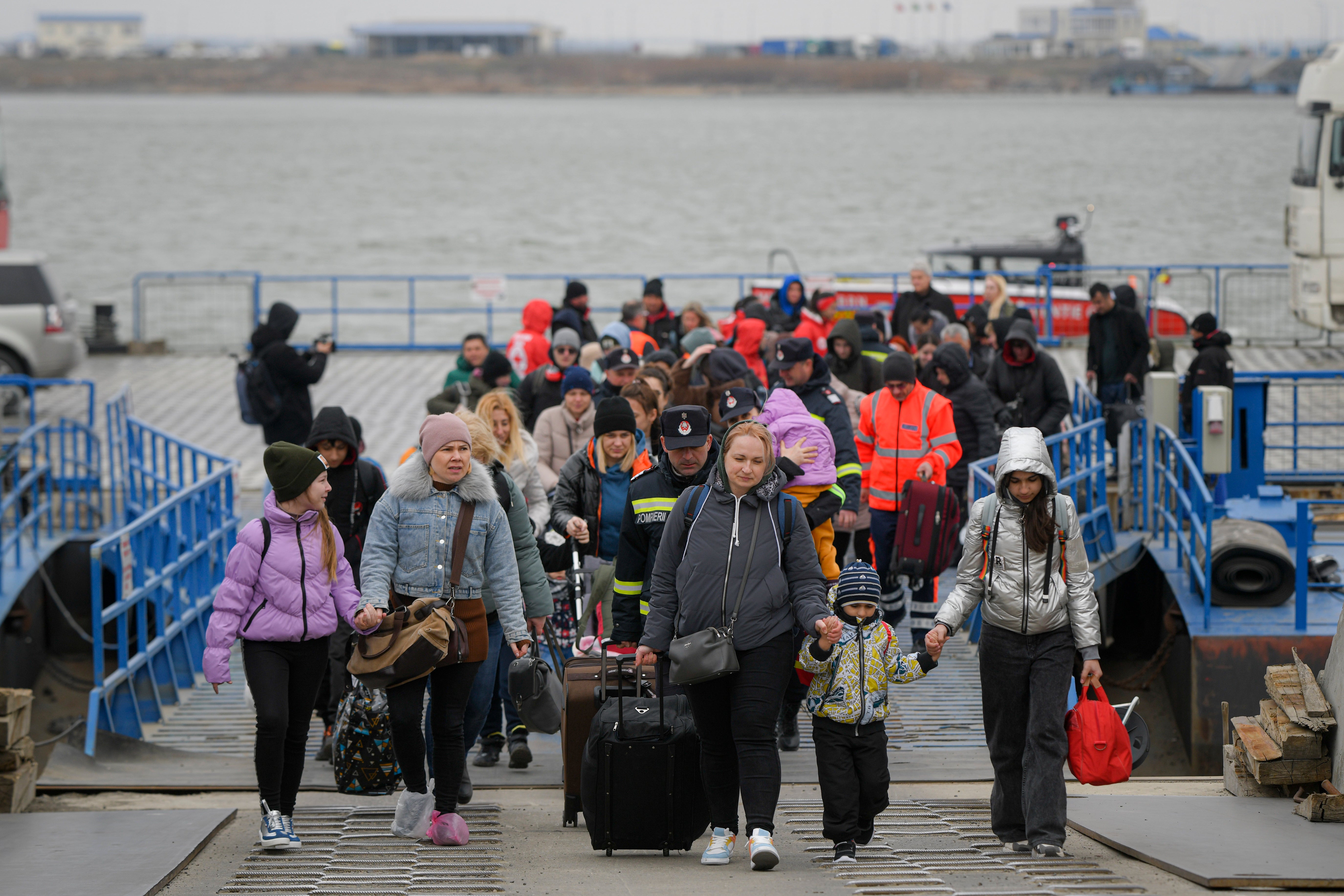 Refugees fleeing the war from neighbouring Ukraine crossing the border by ferry in Romania (Andreea Alexandru/AP)