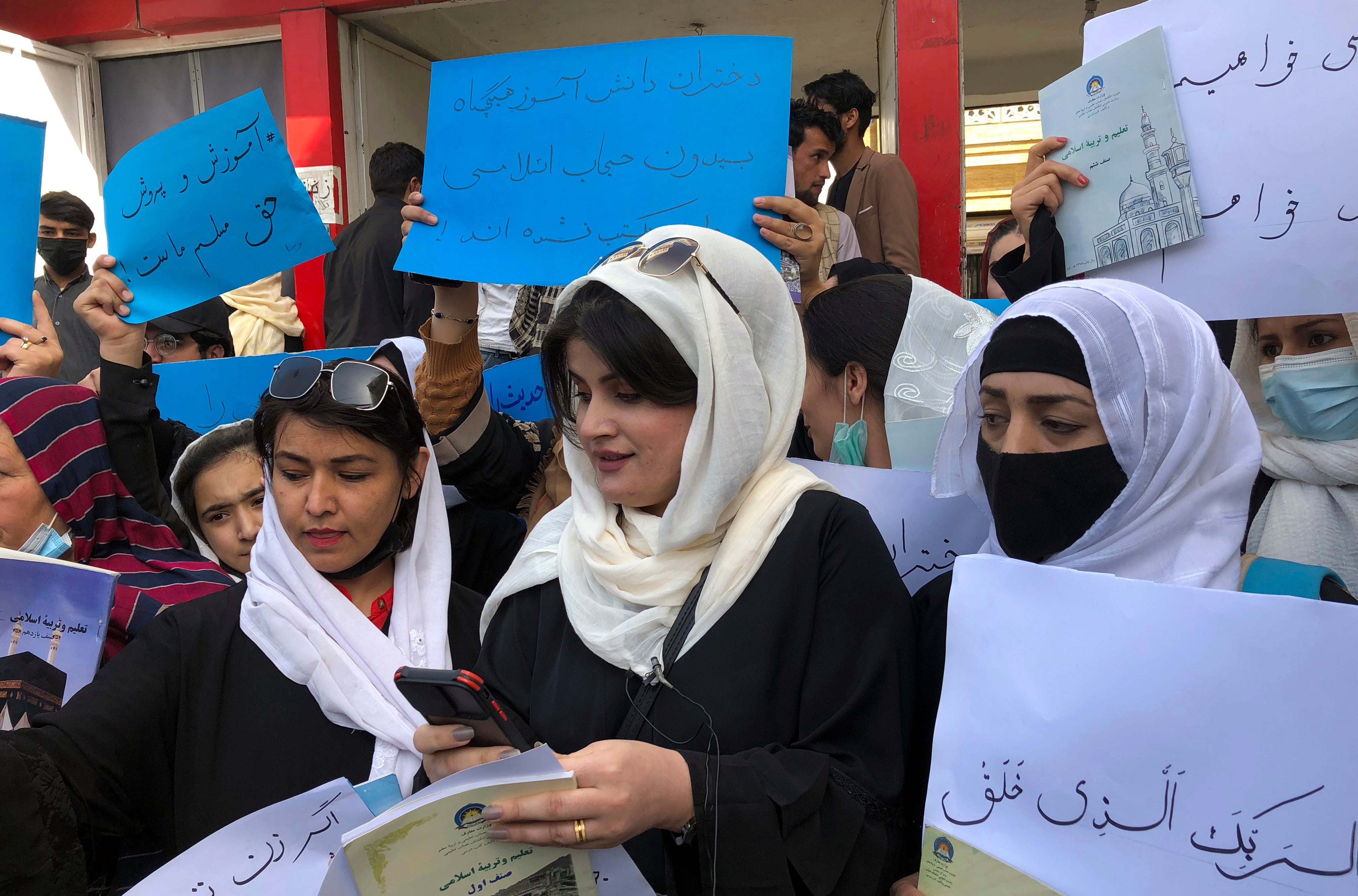 Afghan women chant and hold signs to protest during a demonstration in Kabul, Afghanistan,