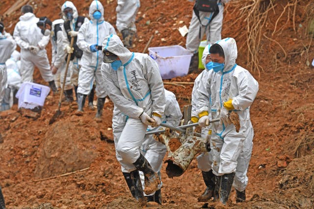 <p> In this photo released by Xinhua News Agency, rescuers carry a piece of plane wreckage at the site</p>