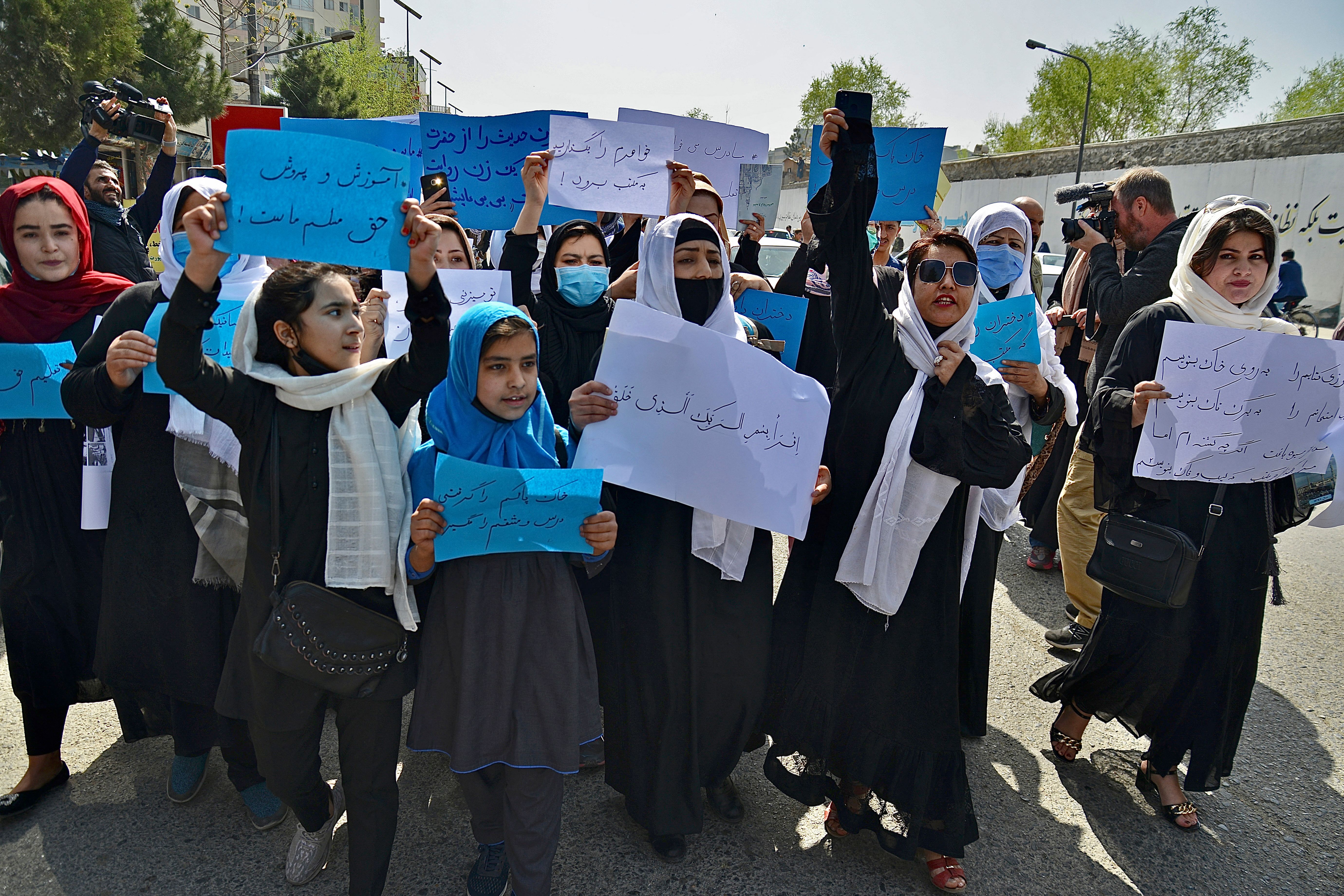 Afghan women and girls take part in a protest in front of the Ministry of Education in Kabul demanding that high schools be reopened for girls