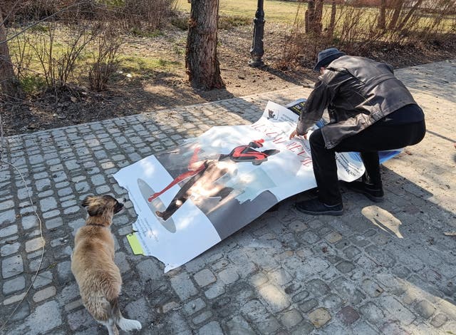 <p>A local man in Sievierodonetsk covers a body of a person killed by shelling with a theatre poster, as Russia’s attack on Ukraine continues</p>