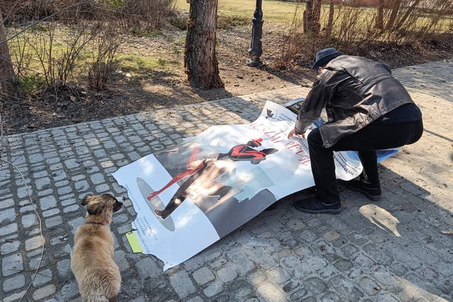 <p>A local man in Sievierodonetsk covers a body of a person killed by shelling with a theatre poster, as Russia’s attack on Ukraine continues</p>