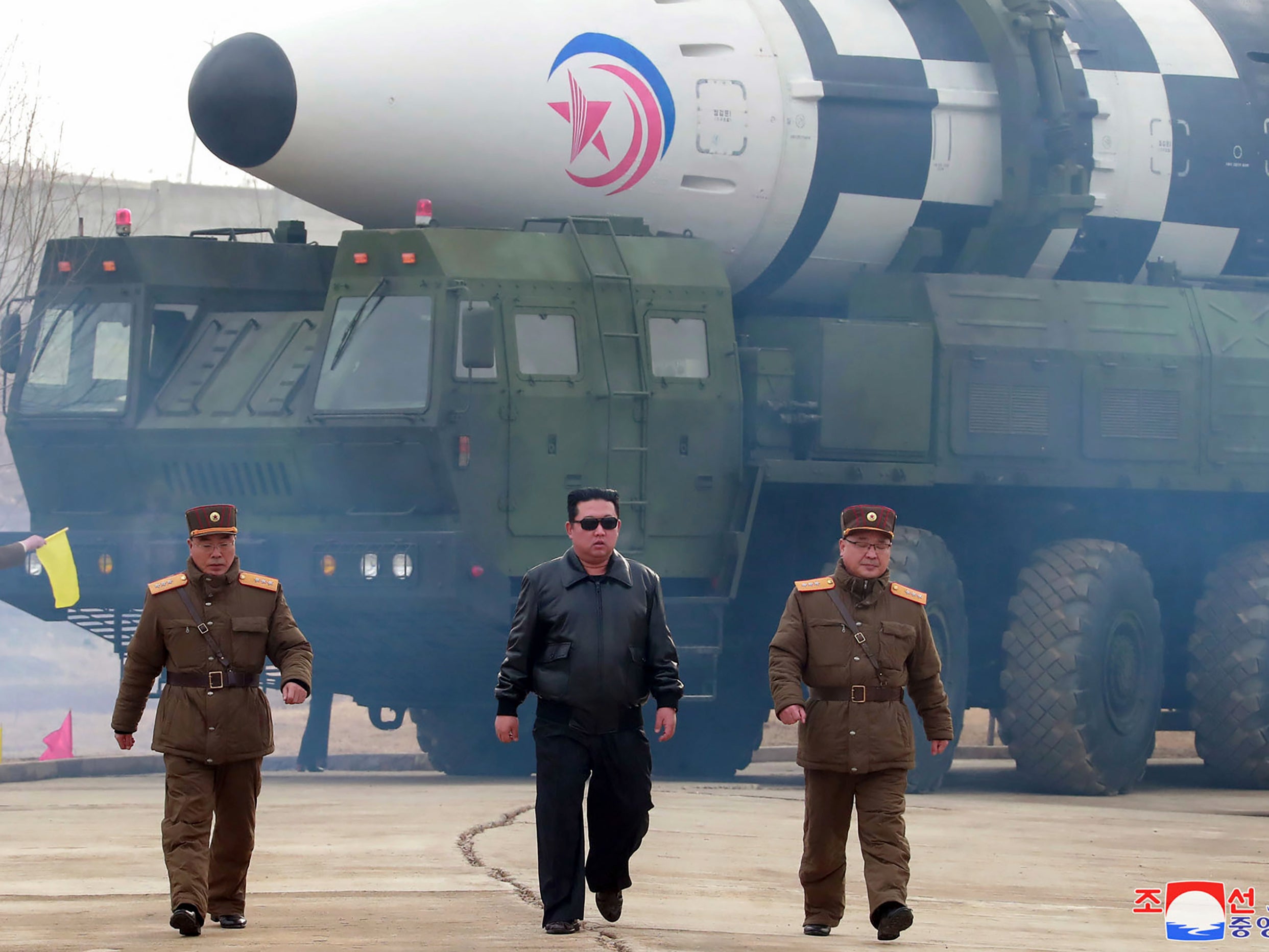 North Korean leader Kim Jong-un (centre) walks around what it says is a Hwasong-17 intercontinental ballistic missile on a launcher at an undisclosed location in North Korea