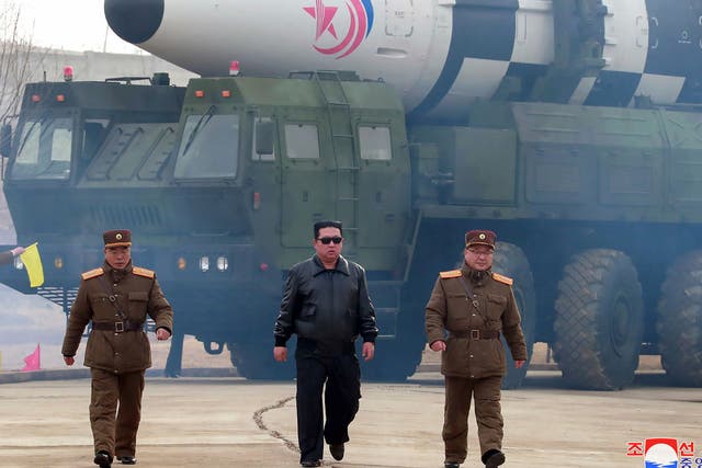 <p>In this photo distributed by the North Korean government, North Korean leader Kim Jong-un, center, walks around what it says is a Hwasong-17 intercontinental ballistic missile (ICBM) on the launcher on 24 March</p>