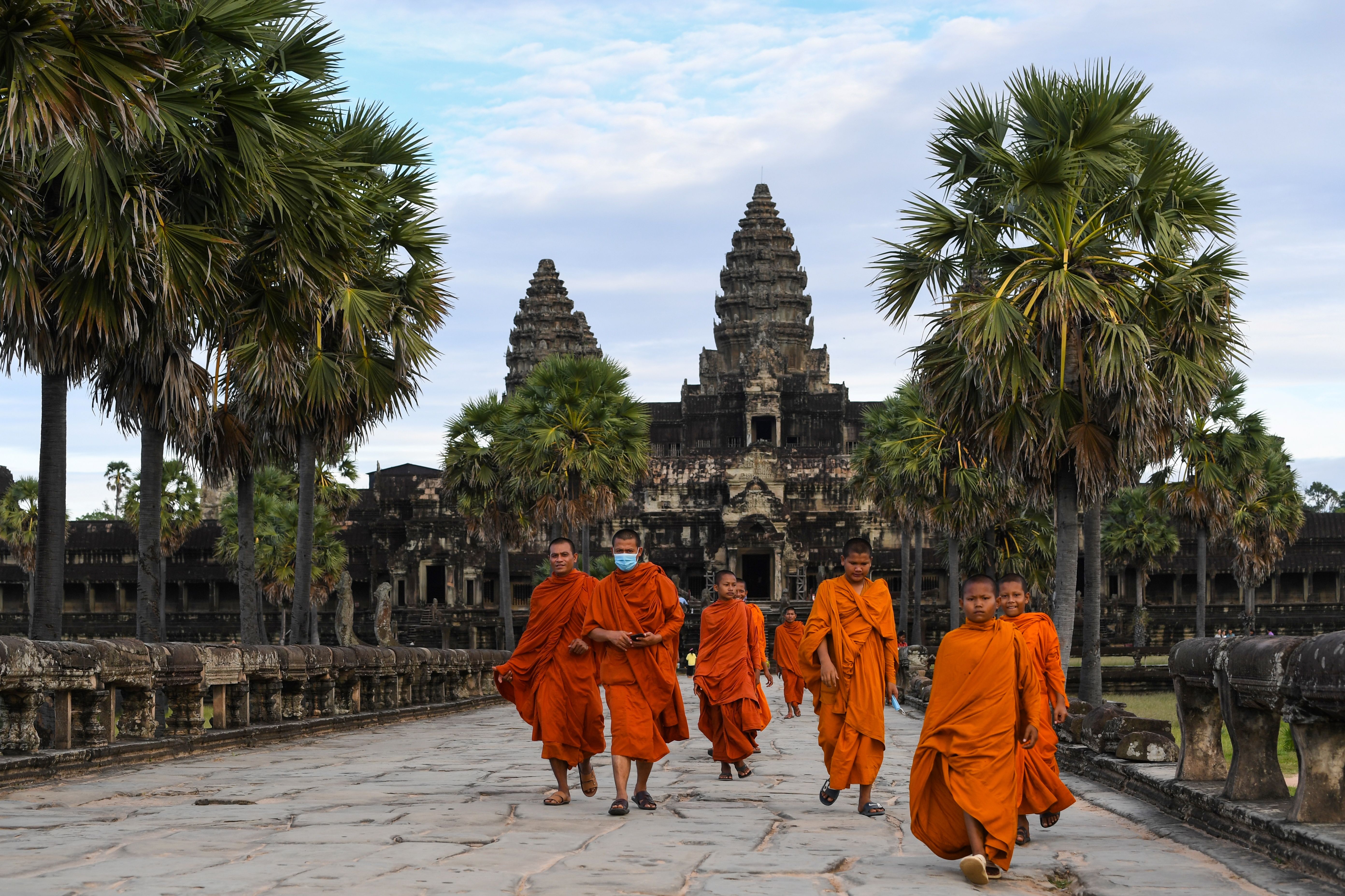Buddhist monks walk around a deserted Angkor Wat in November 2020