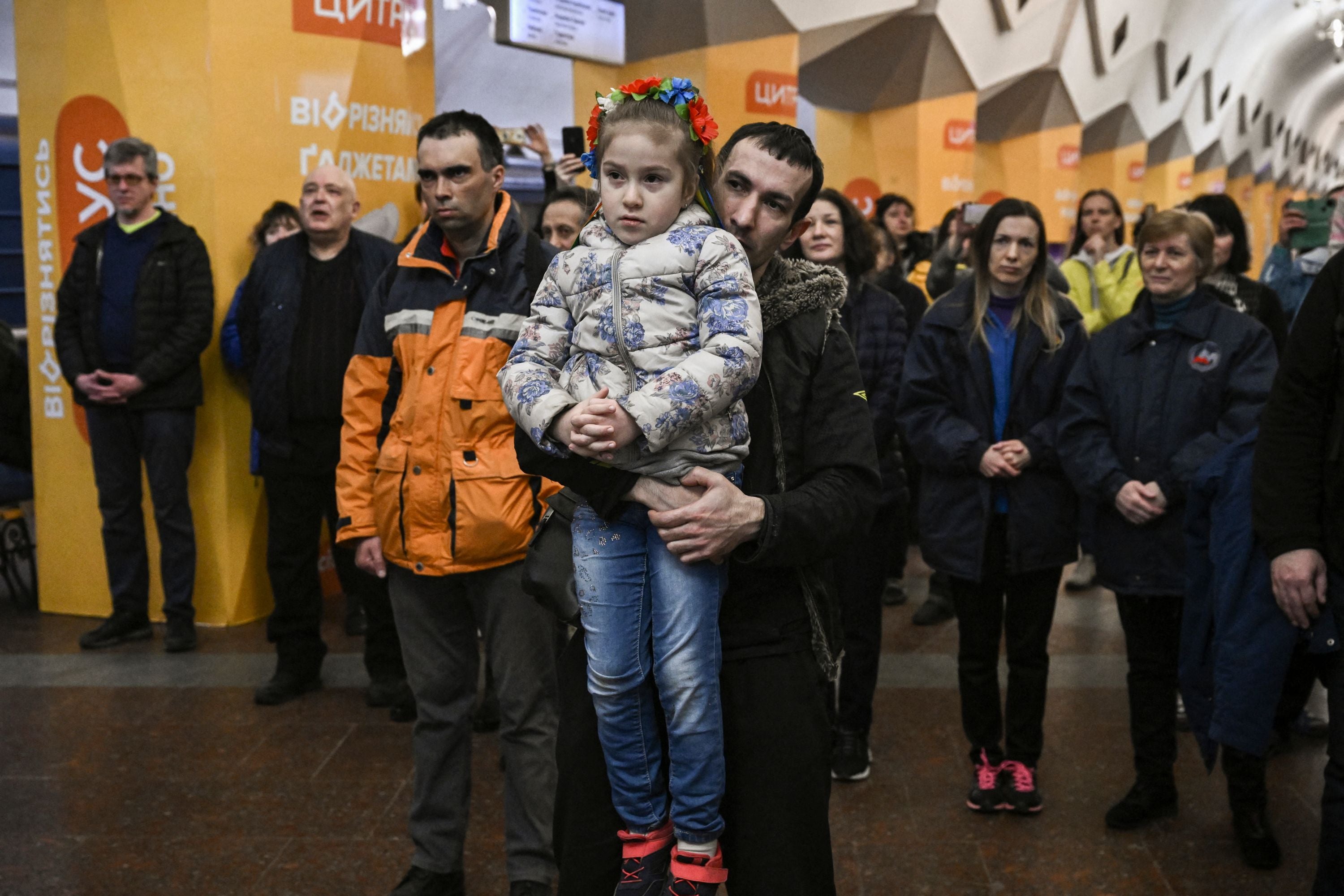 People living in a metro station used as a bomb shelter listen to musicians playing for them in Kharkiv, 26 March 2022
