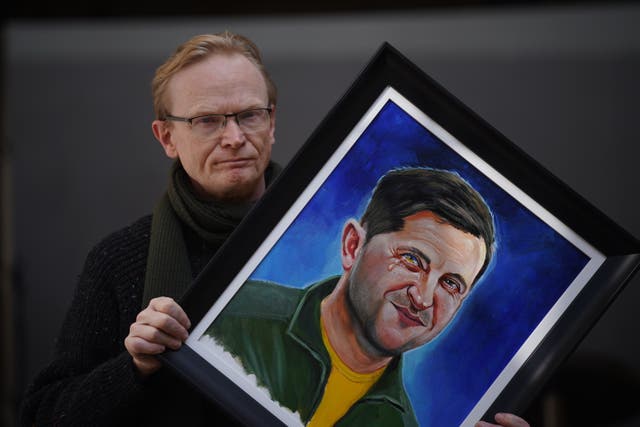 Gallery owner Frank O’Dea with the painting of Volodymyr Zelensky (Niall Carson/PA)