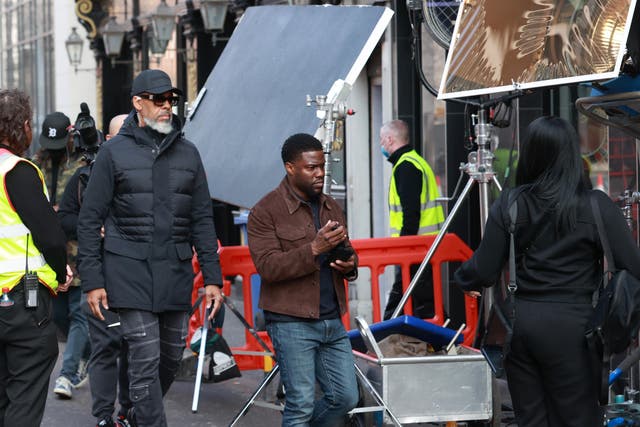 Kevin Hart (centre) on set during the filming of Lift at the Crown Bar in Belfast (/PA)