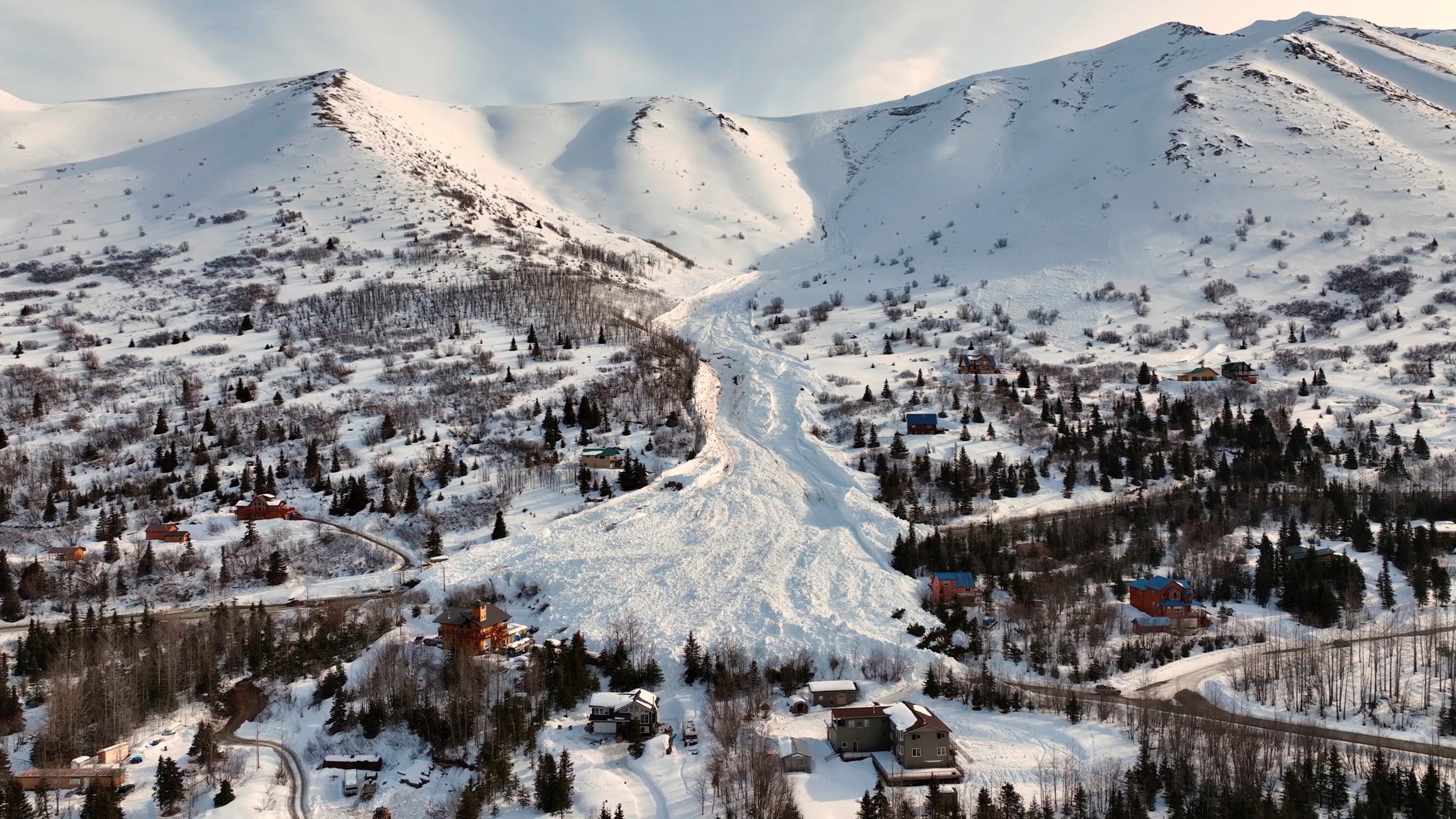 Drone footage shows the aftermath of an avalanche down a mountainside at Hiland Road in Anchorage, Alaska on March 27