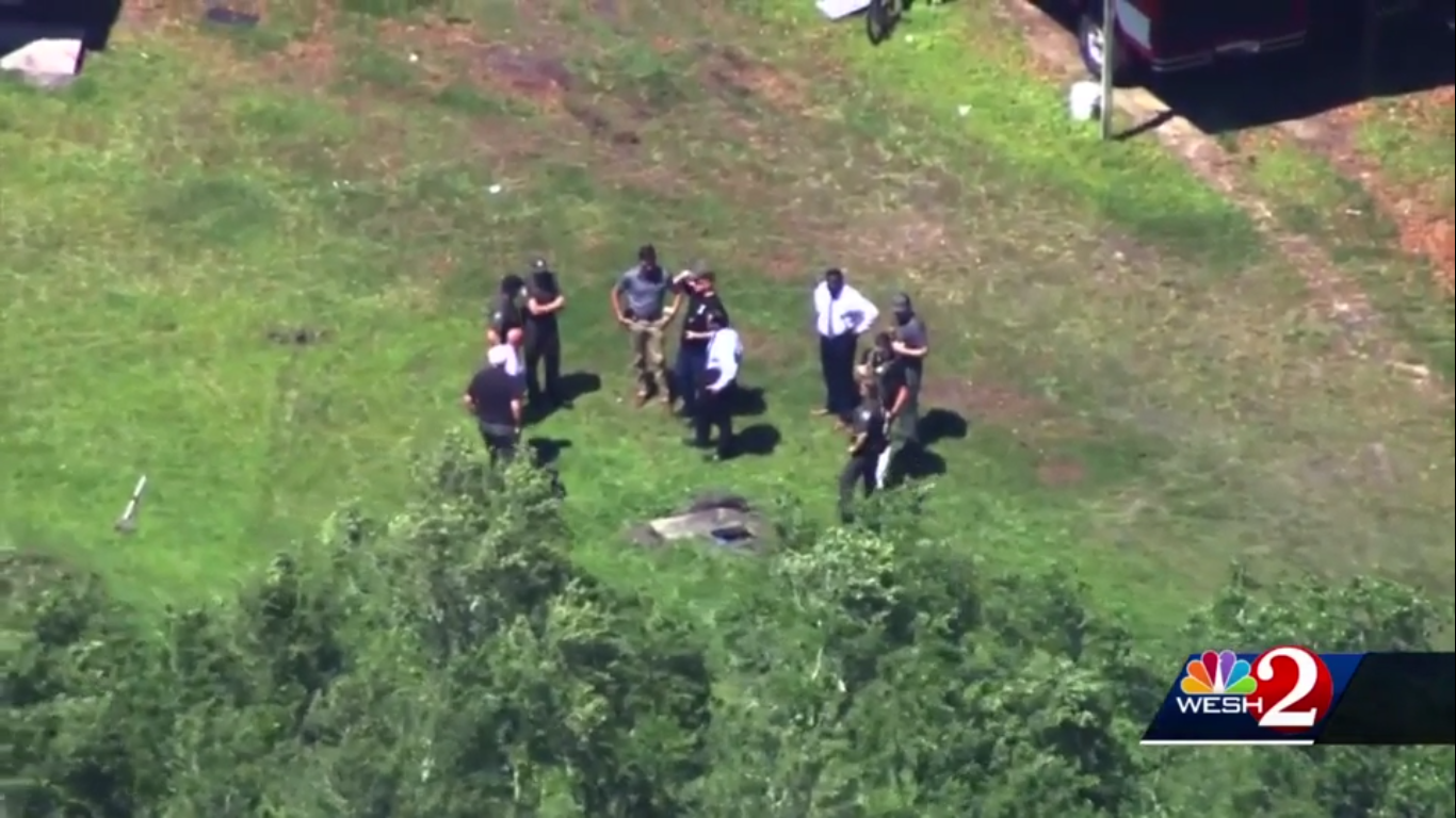 Authorities stand over the body of Jose Lara after he was discovered in a septic tank