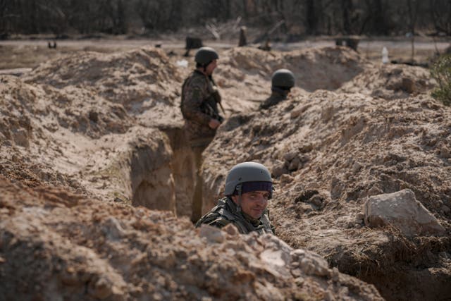 <p>Ukrainian servicemen stand in trenches at a position north of the capital Kyiv</p>