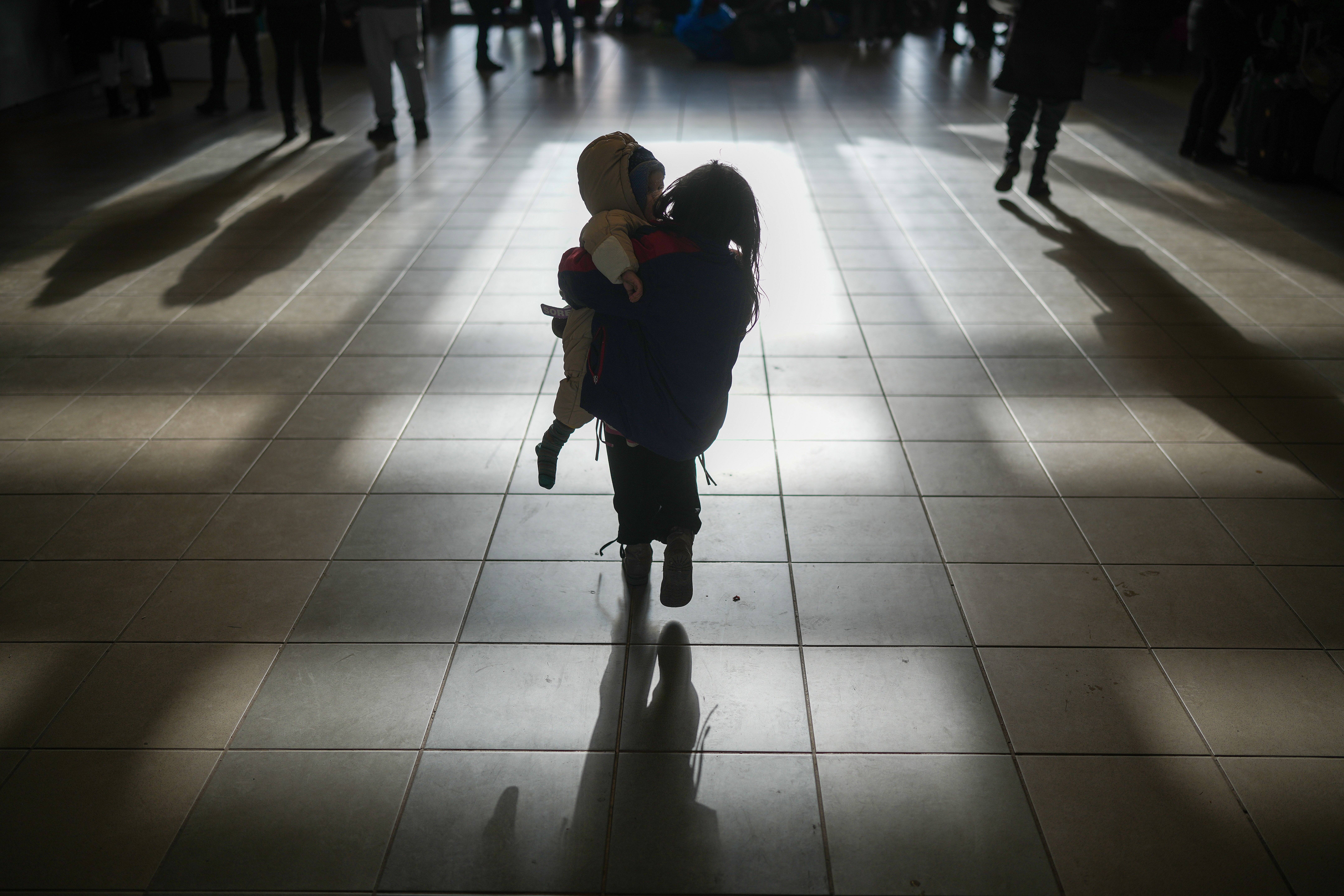 File photo: a Ukrainian refugee girl carries a sibling after arriving by train at the Hungarian border town of Zahony in early March