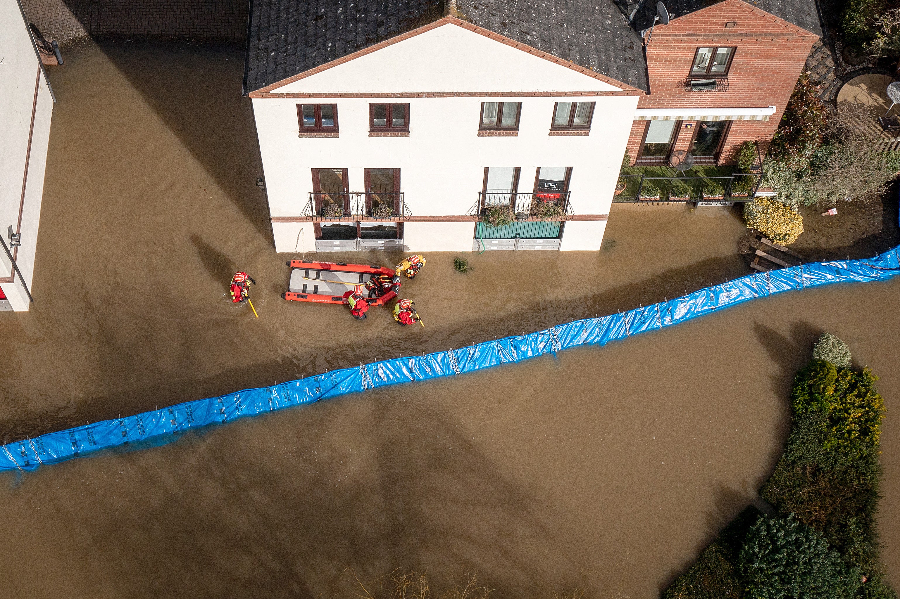 Rescuers wade through flood water in Bewdley to check on the welfare of residents after the River Severn breached defences on 23 February 2022 in Worcestershire