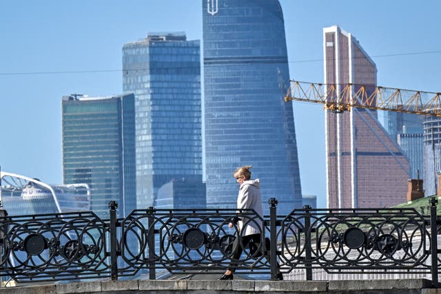 <p>A woman walks on a bridge in central Moscow on 23 March 2022</p>