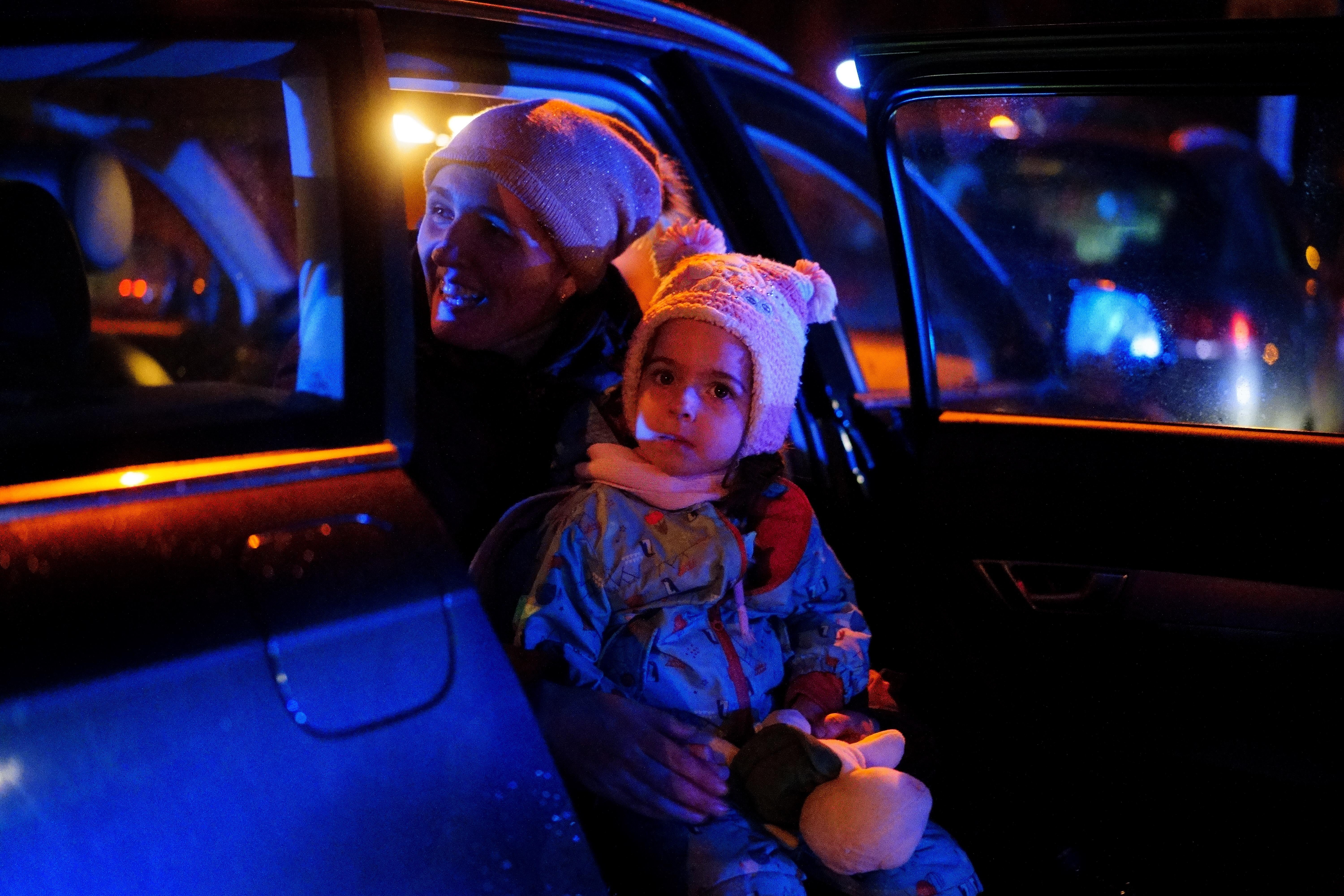 A Ukrainian woman holds her child as they wait to board a train to return to Ukraine, outside Przemysl Glowny train station in east Poland (Victoria Jones/PA)