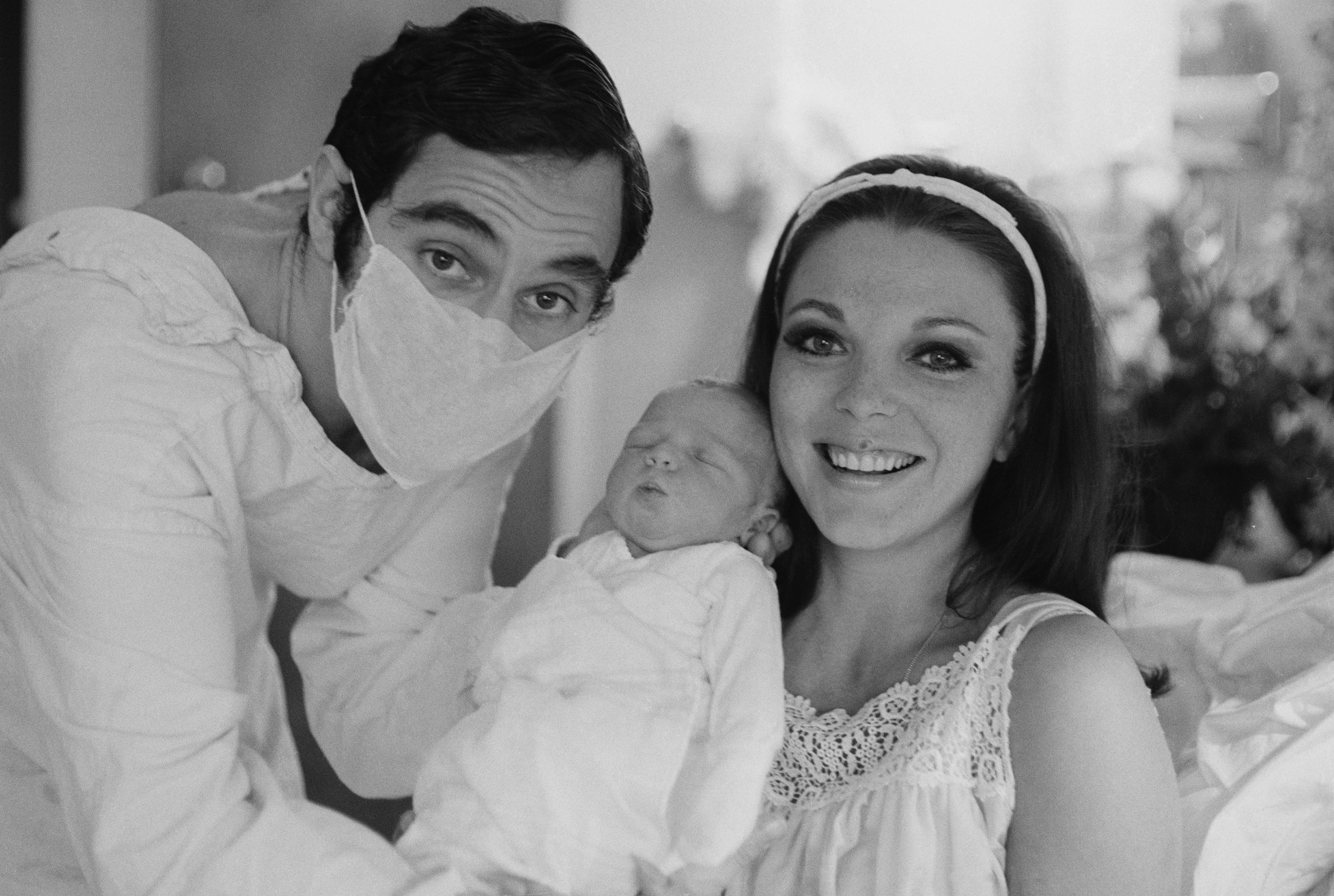 Collins and Anthony Newley hold their newly born baby, Sacha, 24 September 1965