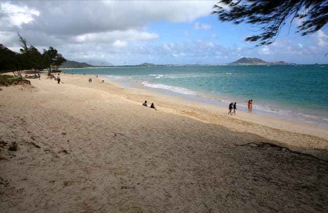<p>People walk on the beach in Kailua, Hawaii</p>