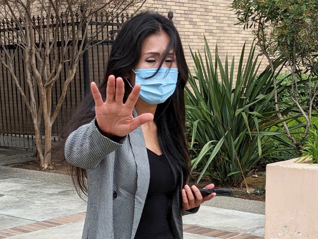 <p>Julie Lee Choi waves off reporters outside Santa Clara Superior Court in San Jose, Calif., on Tuesday, March 29, 2022</p>