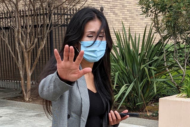 <p>Julie Lee Choi waves off reporters outside Santa Clara Superior Court in San Jose, Calif., on Tuesday, March 29, 2022</p>