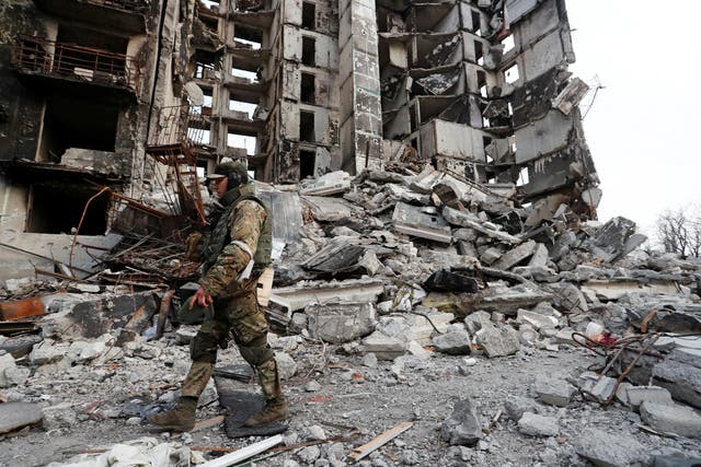 <p>A service member of pro-Russian troops walks on the ruins of an apartment building destroyed during Ukraine-Russia conflict in the besieged southern port city of Mariupol</p>