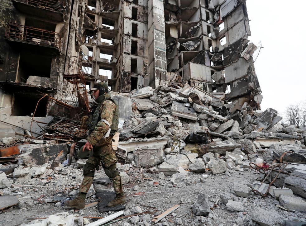 <p>A service member of pro-Russian troops walks on the ruins of an apartment building destroyed during Ukraine-Russia conflict in the besieged southern port city of Mariupol</p>