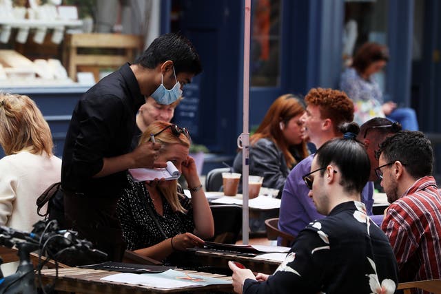 A waiter takes orders at a restaurant. VAT on food is set to increase among a raft of tax changes coming into force in April (Brian Lawless/PA)