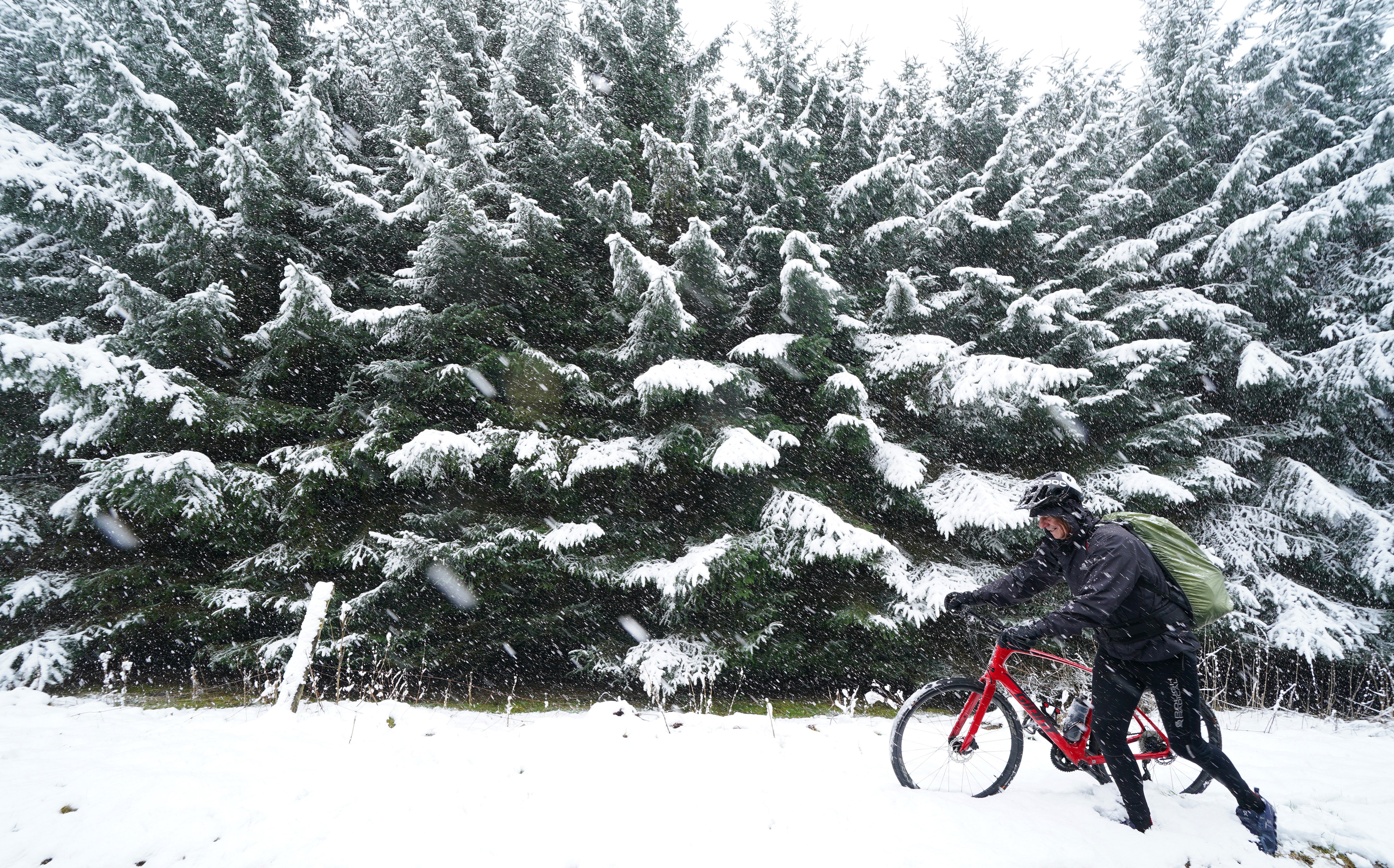 Coast-to-coast cyclist Terry Smith from Coventry hits snow in Allenheads, in the Pennines to the north of Weardale in Northumberland (Owen Humphreys/PA)