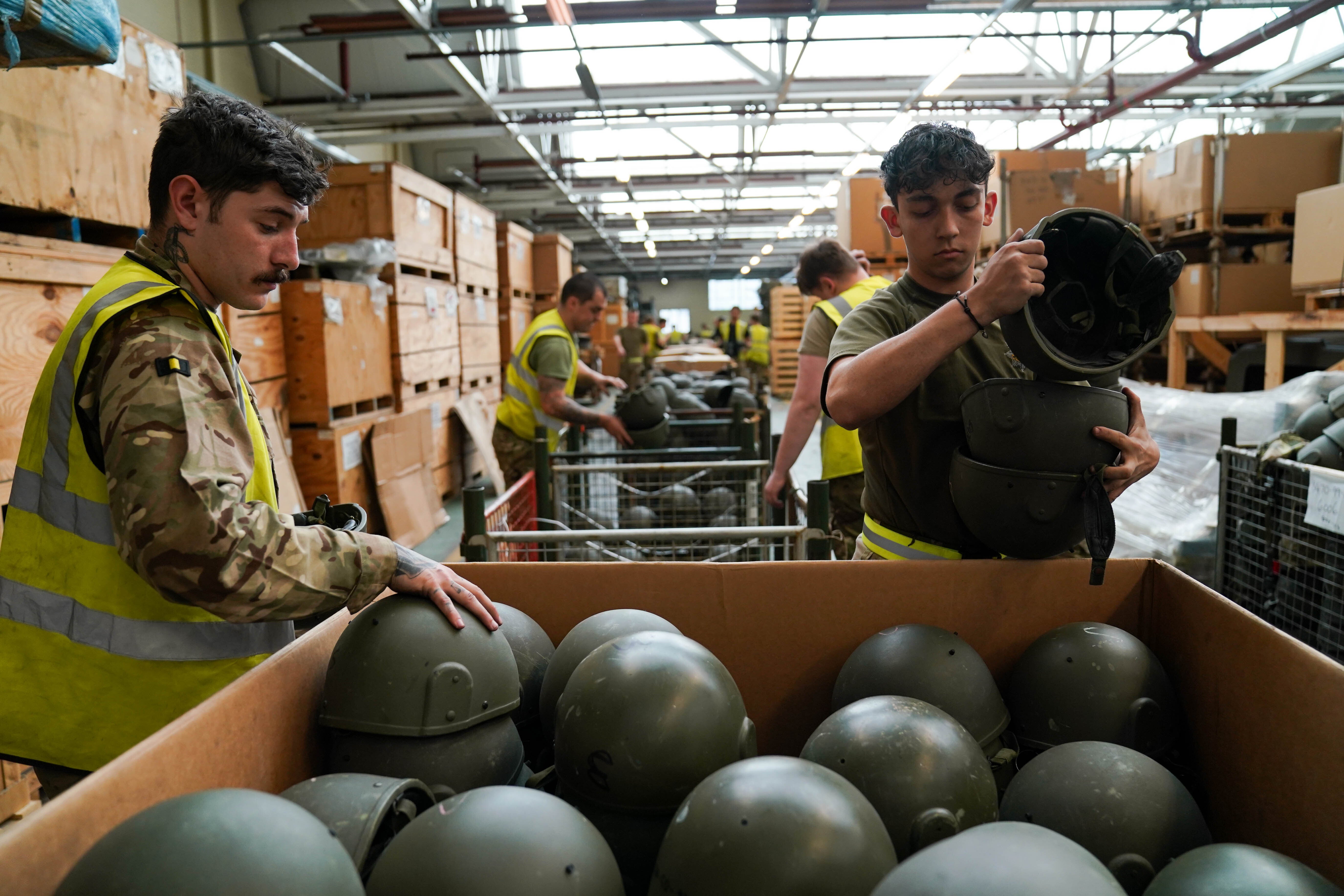 British military labels being removed from kit before its despatch to Poland (Jacob King/PA)