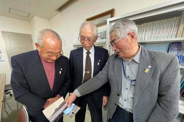 <p>Yasuji Tsunoka, Hirotoshi Kawata and Hiroshi Tokuno, former residents of the Northern Territories, look at photos from their home islands</p>