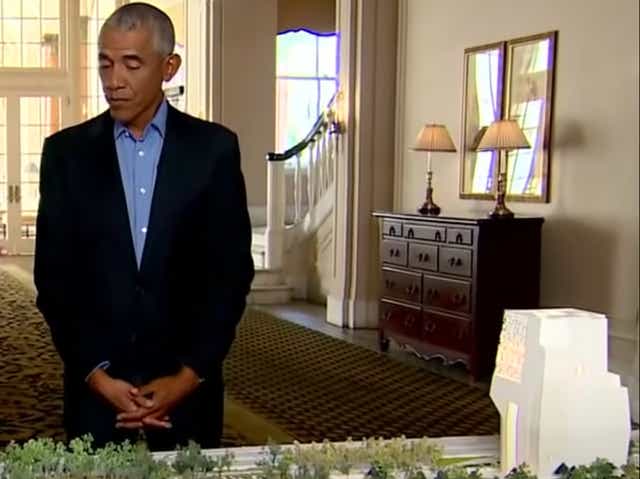 <p>Former President Barack Obama standing over a model of the Obama Presidential Centre, which is planned to be built in Jackson Park in Chicago</p>