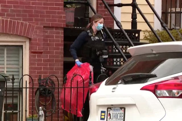 <p>Officers are seen carrying biohazard bags out of the basement of the property </p>