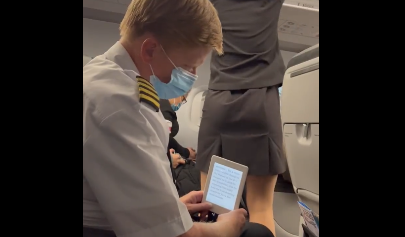 The pilot appears to hide his phone behind a Kindle in order to snap photos