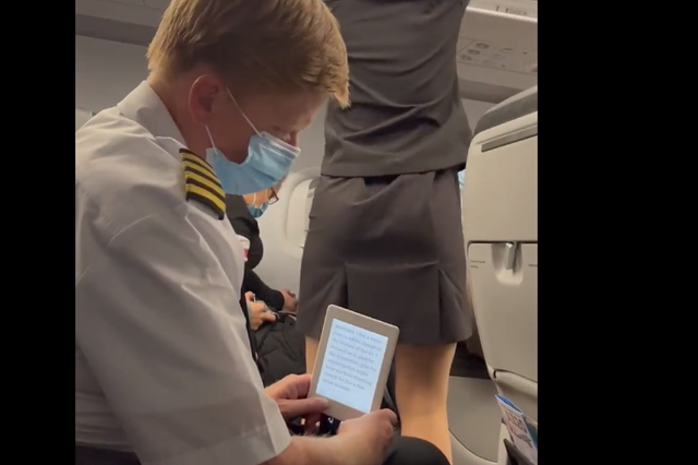 <p>The pilot appears to hide his phone behind a Kindle in order to snap photos</p>
