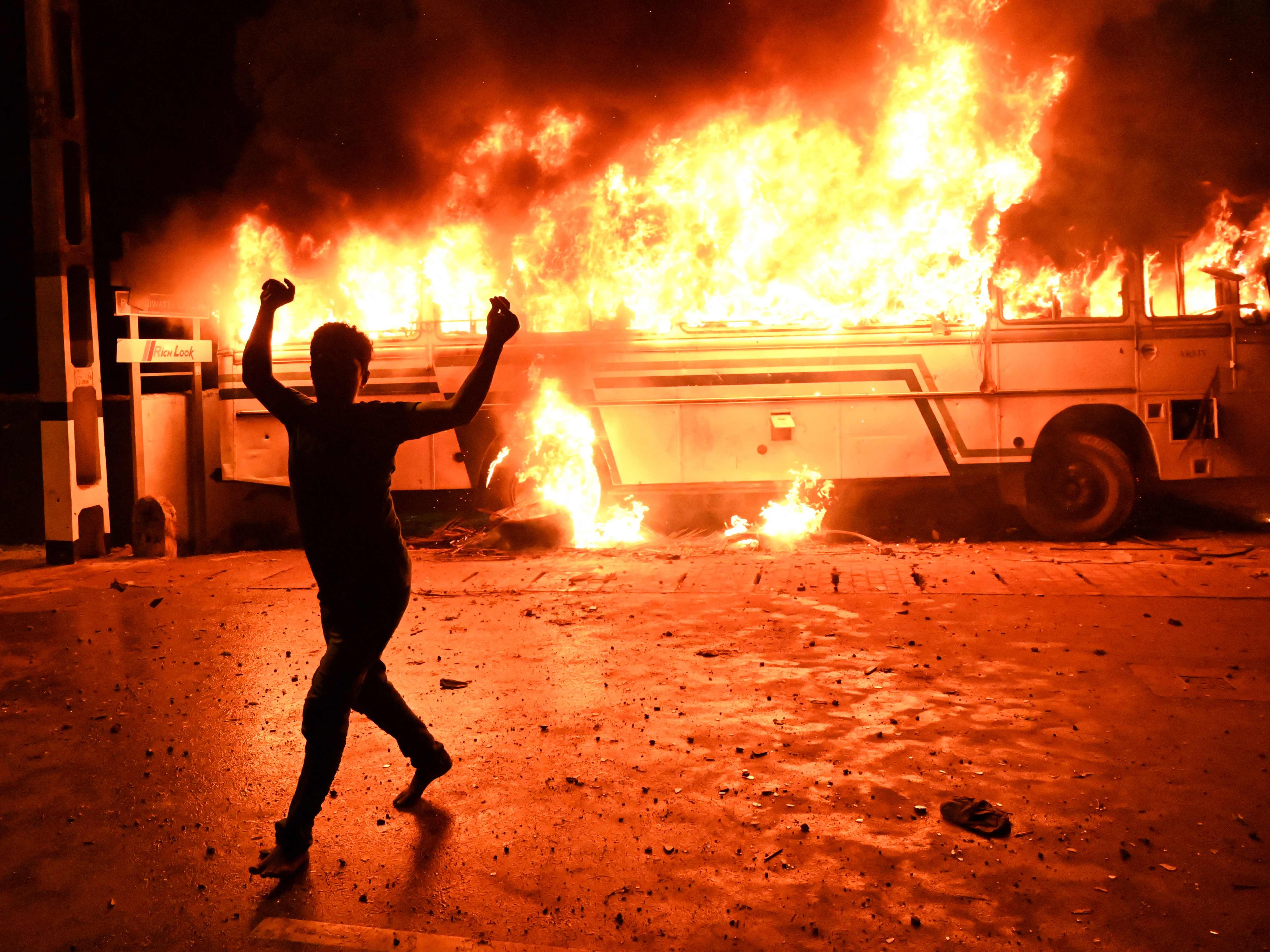 <p>A protester shouts slogans after setting a bus on fire during a demonstration outside the Sri Lankan president's home on 31 March </p>