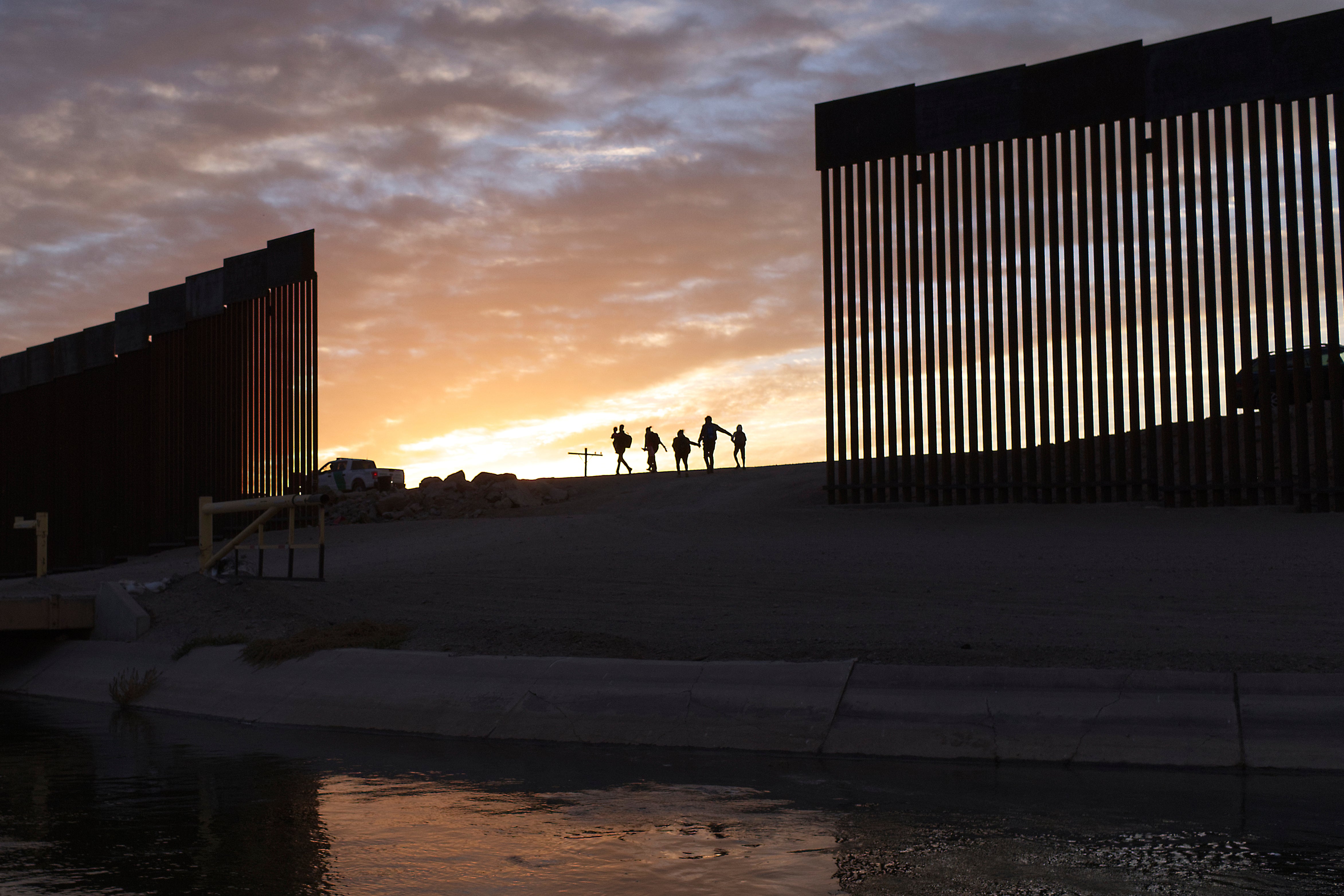 Migrants pass through a gap in the border wall near Yuma in Arizona (file)