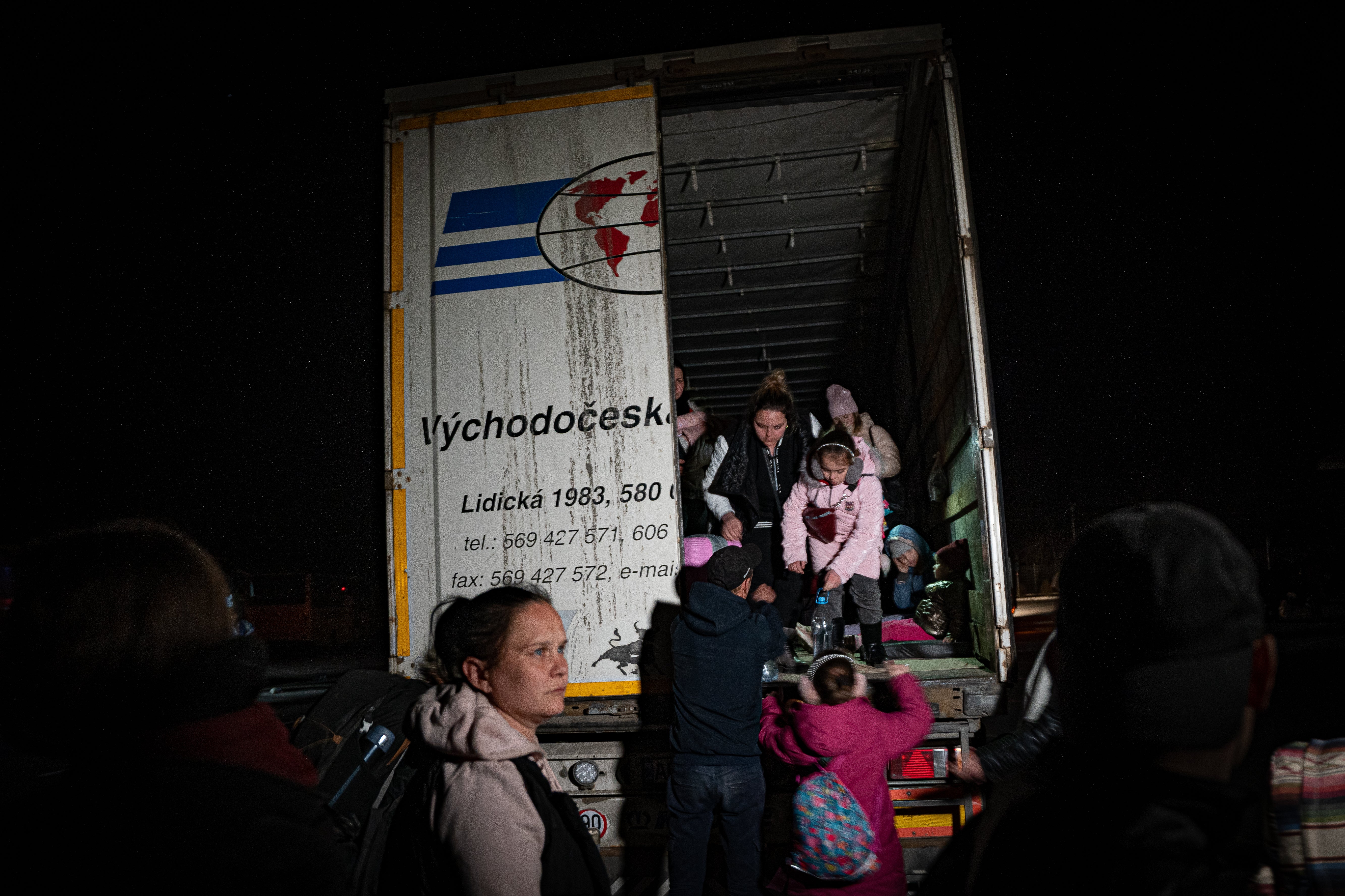 Civilians flee frontline areas in the back of articulated trucks, embarking on 11-hour journeys