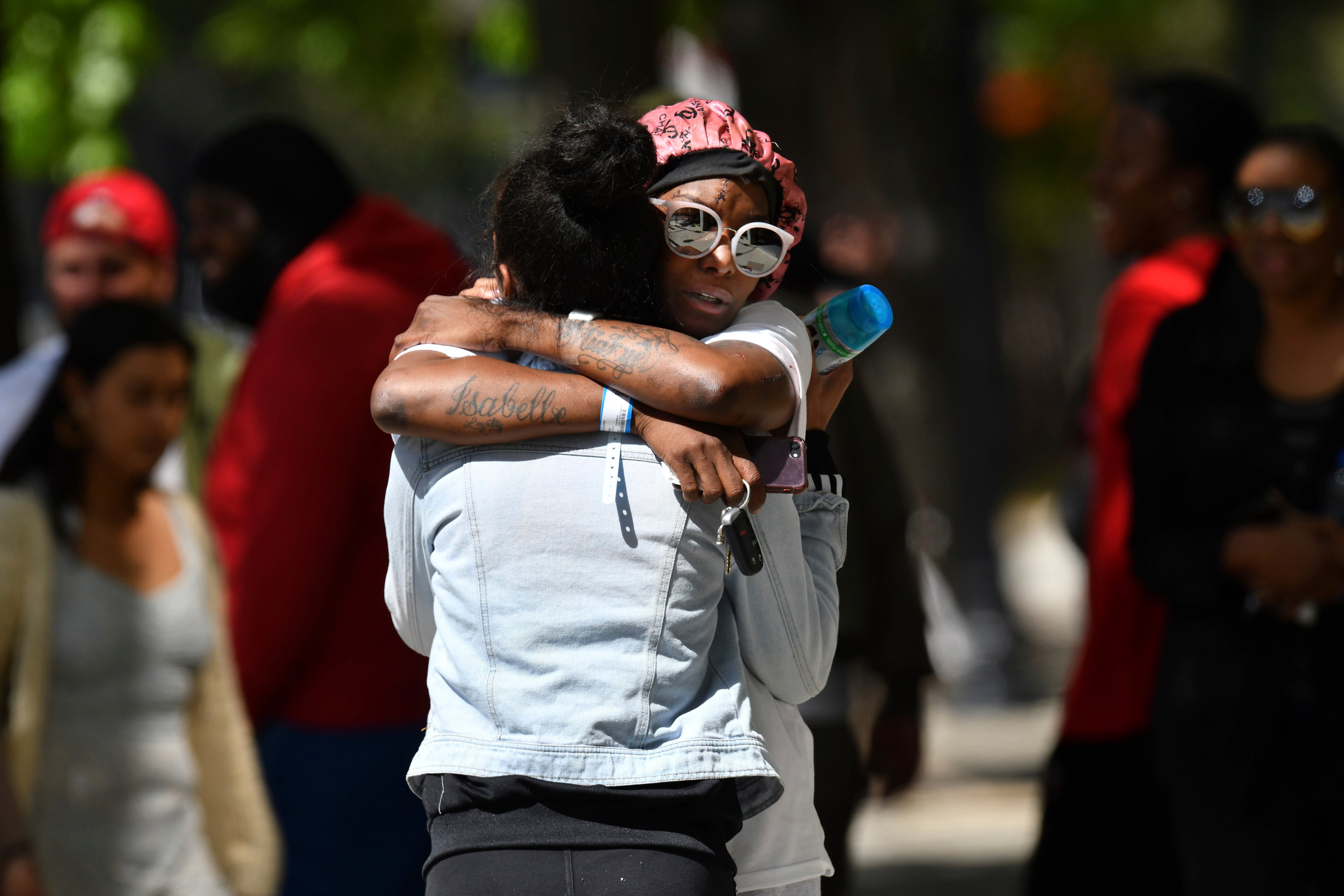 Two women hug each other at the scene of a mass shooting in Sacramento, Calif., on Sunday, 3 April