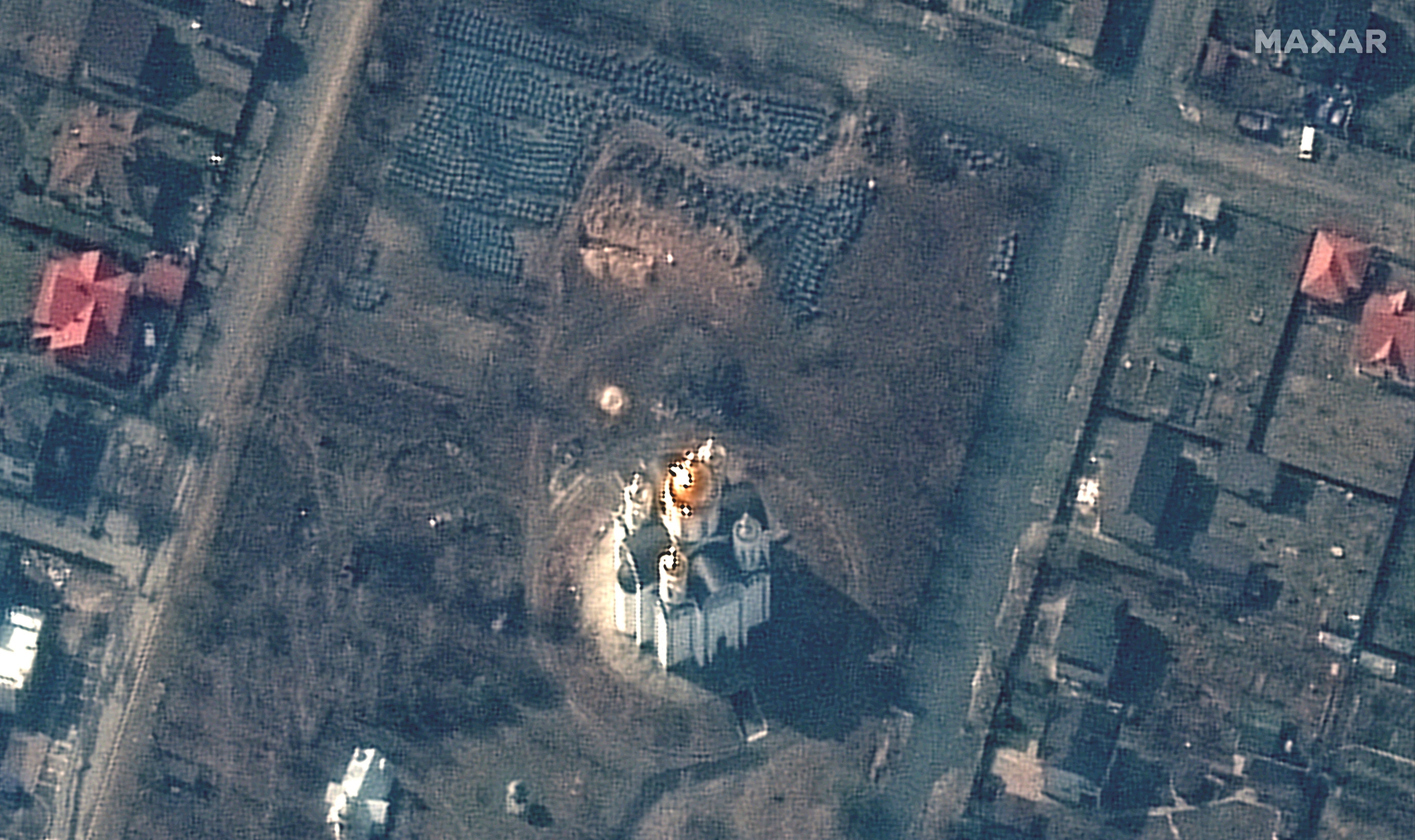 A satellite image shows the grave site with an approximately 45-foot long trench near the Church of St. Andrew and Pyervozvannoho All Saints, in Bucha