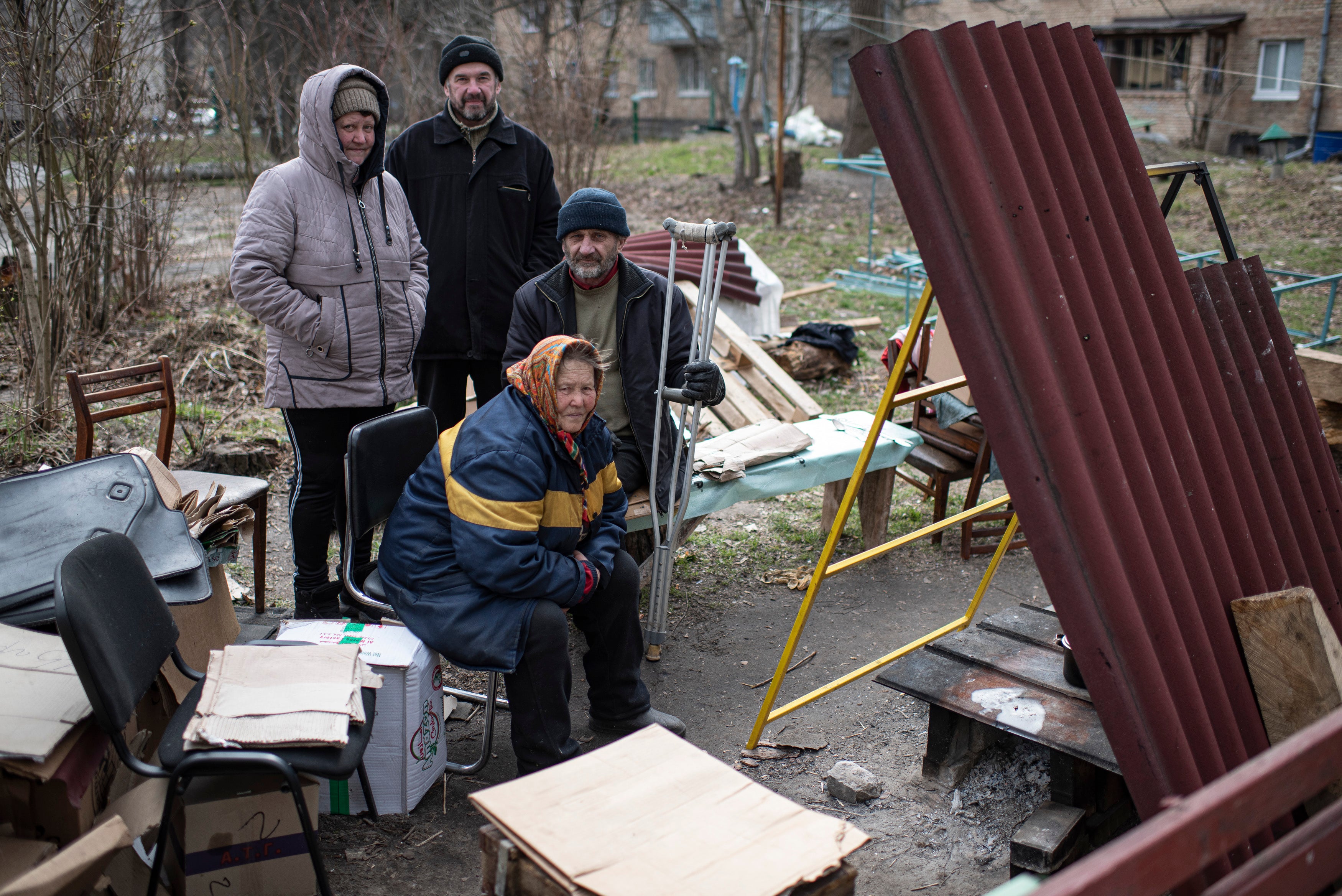 Residents sit by a makeshift stove next to their apartment building in Bucha, Ukraine. The Ukrainian government has accused Russian forces of committing a "deliberate massacre" as they occupied and eventually retreated from Bucha