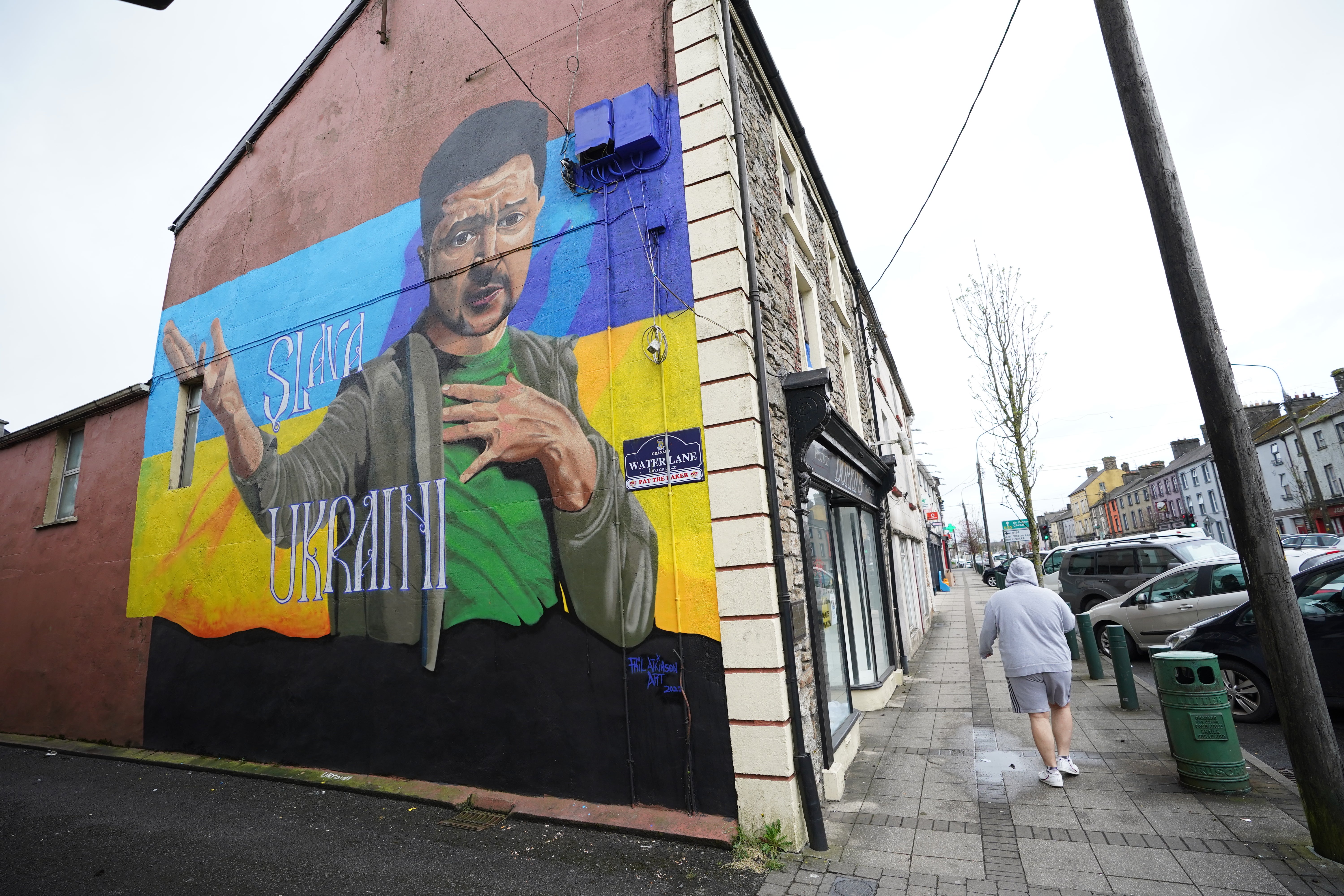 People pass a mural of President of Ukraine Volodymyr Zelenskyy, by the artist Phil Atkinson in Granard, County Longford, Ireland (Niall Carson/PA)