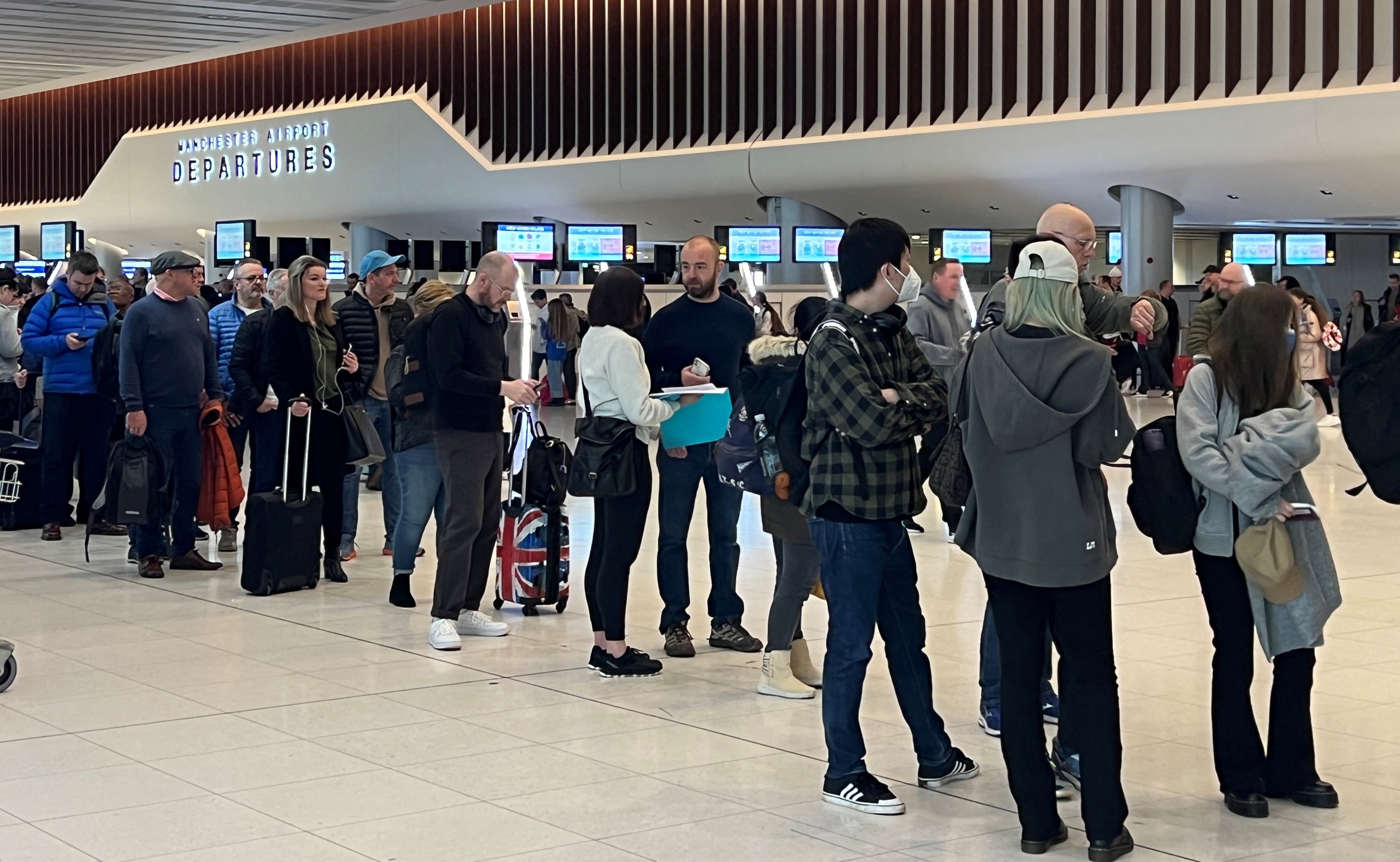Passengers queue for security screening in the departures area of Terminal 2 at Manchester airport