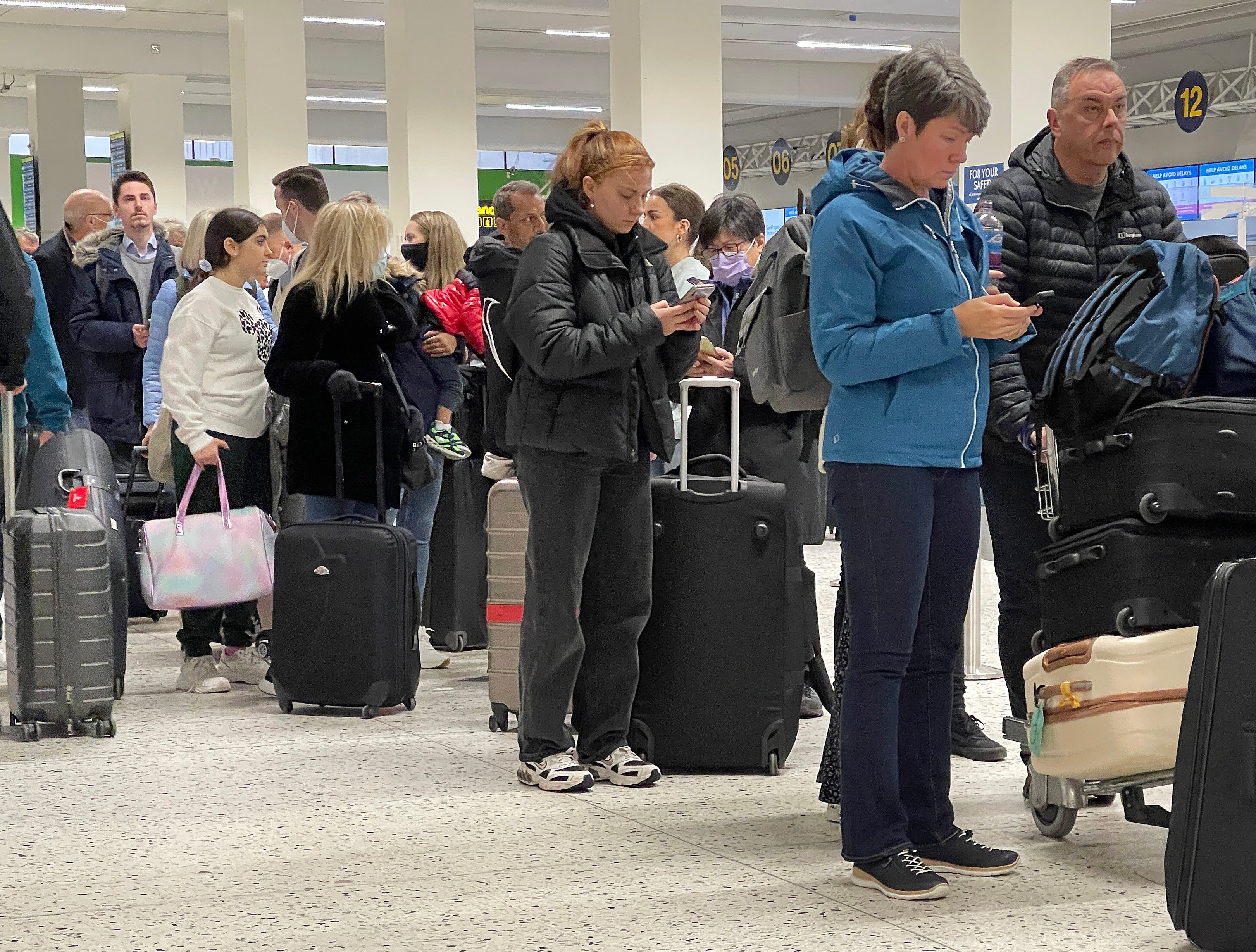 Passengers queue for check-in at Manchester airport's Terminal 1
