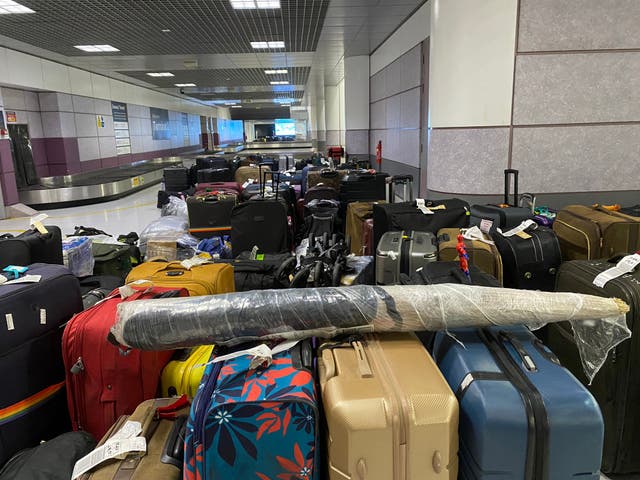 <p>Luggage stacked up at Manchester Airport last night</p>